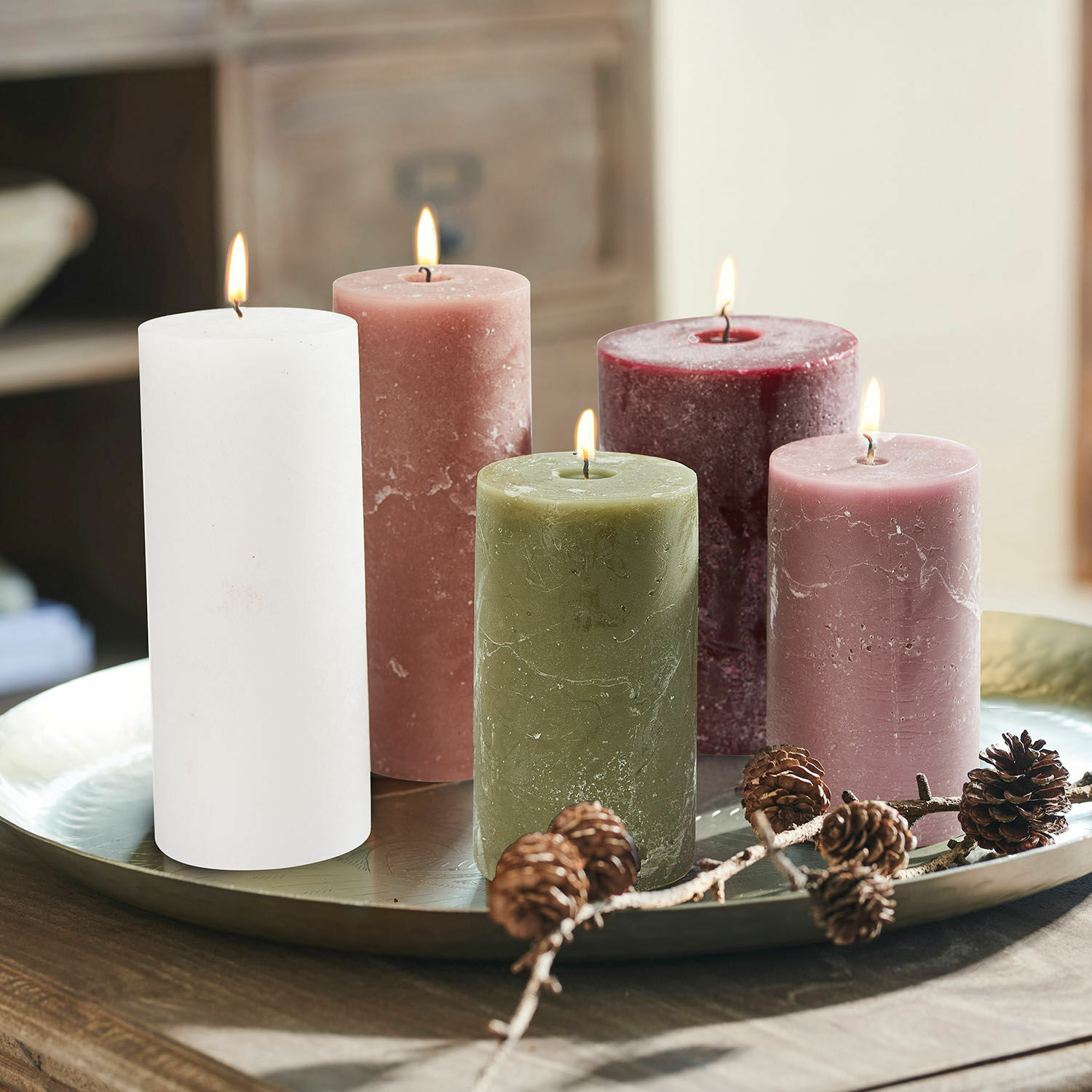 Set de 5 velas Panagra Conjunto de cinco velas de cera en varios colores sobre bandeja metálica con decoración de piñas