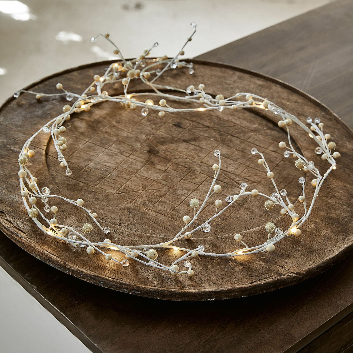 Luces de hadas Hailee Corona decorativa blanca con luces LED y perlas sobre bandeja de madera, decoración luminosa