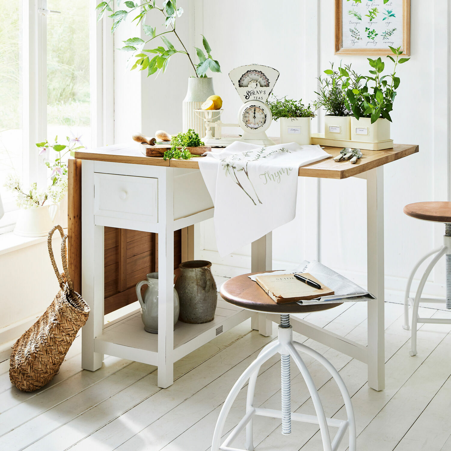Mesa Dale Mesa de cocina blanca de madera con superficie de madera clara y plantas verdes en macetas