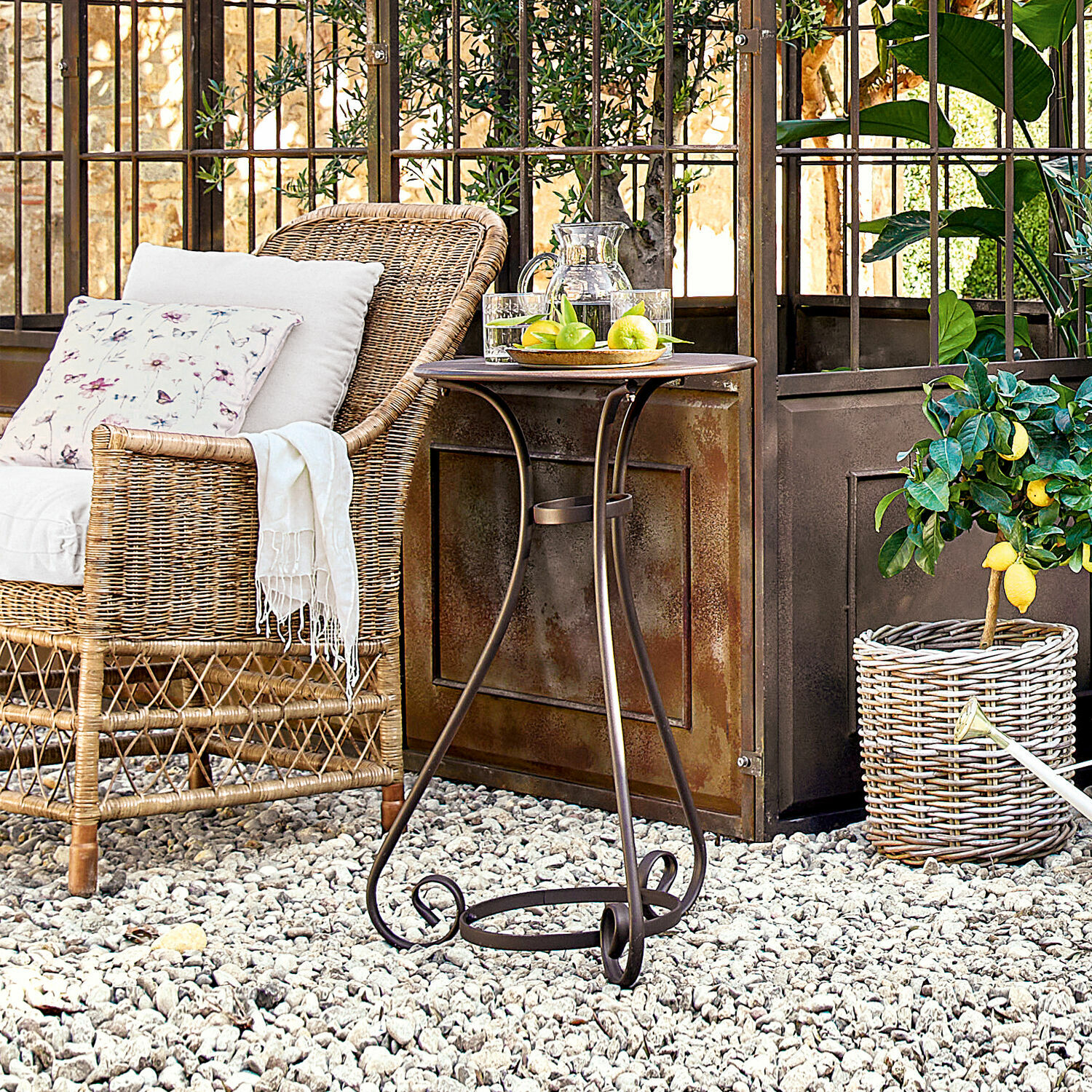 Mesa auxiliar Savigny Mesa de jardín de metal marrón con patas decorativas sobre grava blanca