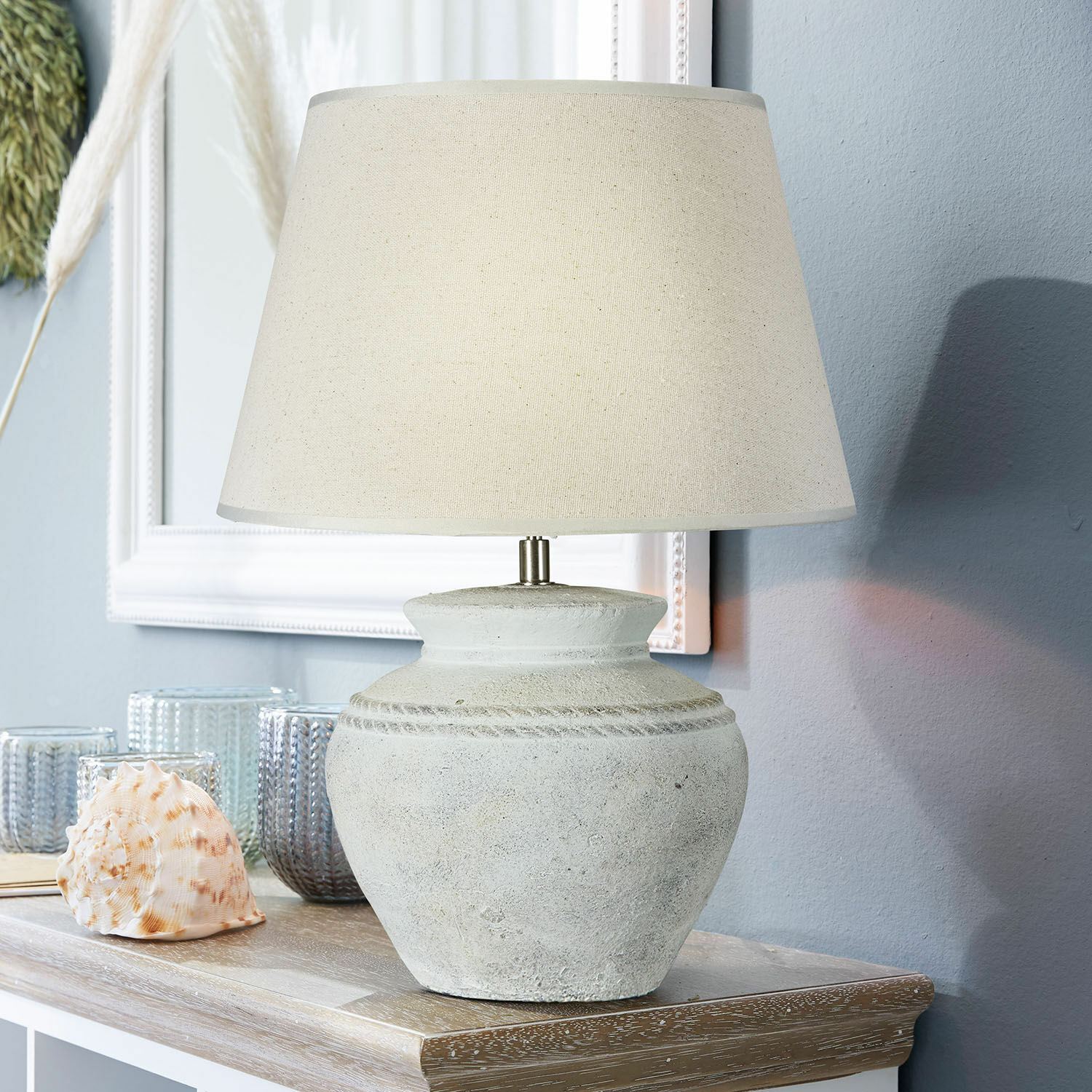 Lámpara de mesa Cleveland Lámpara de mesa con pantalla beige y base de cerámica gris sobre mesa de madera