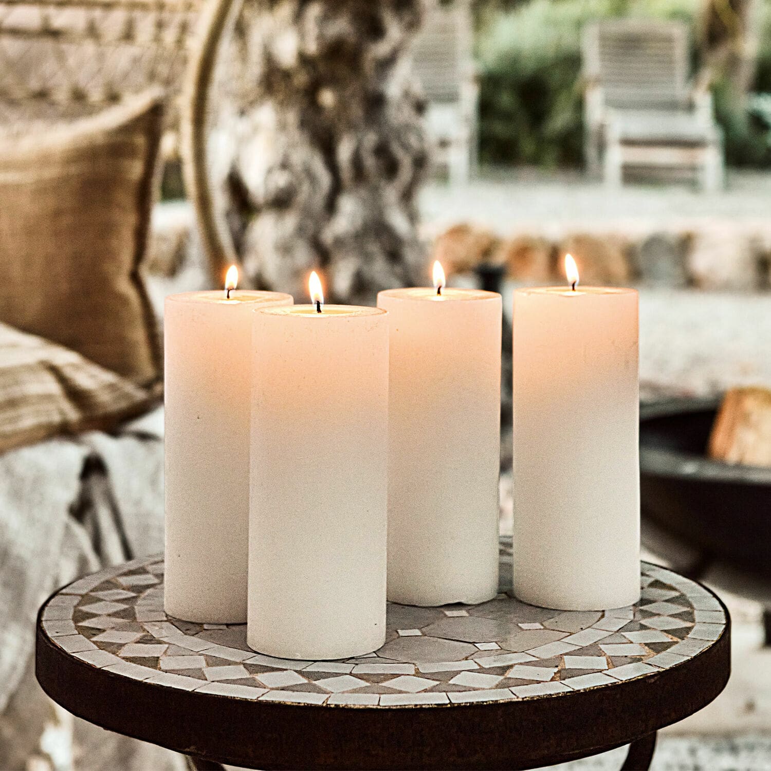 Set de 4 velas Homel Cuatro velas blancas sobre mesa de mosaico, decoración interior y luz ambiental