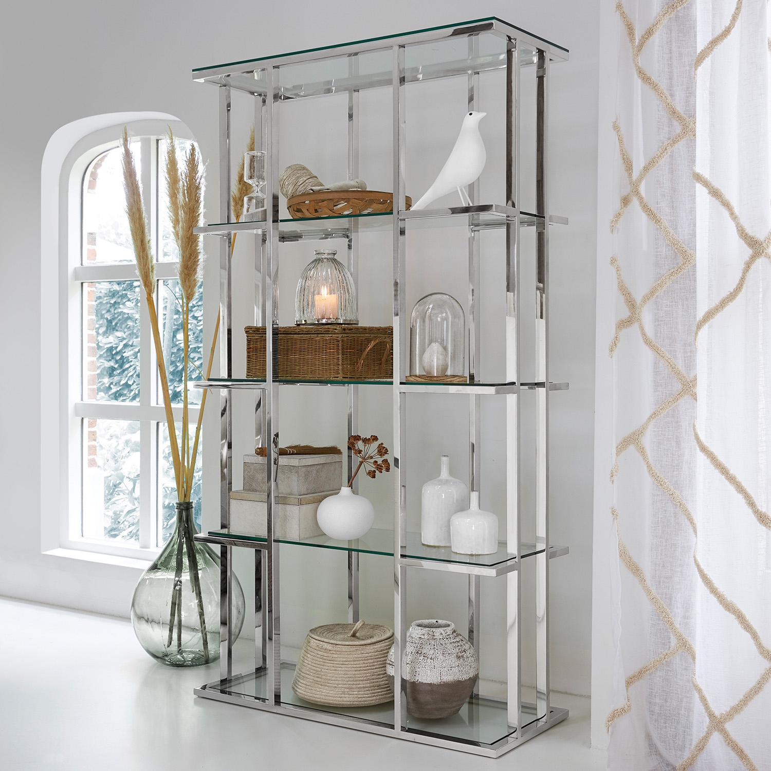 Estantería moderna de vidrio con marco metálico plateado y decoración para salón