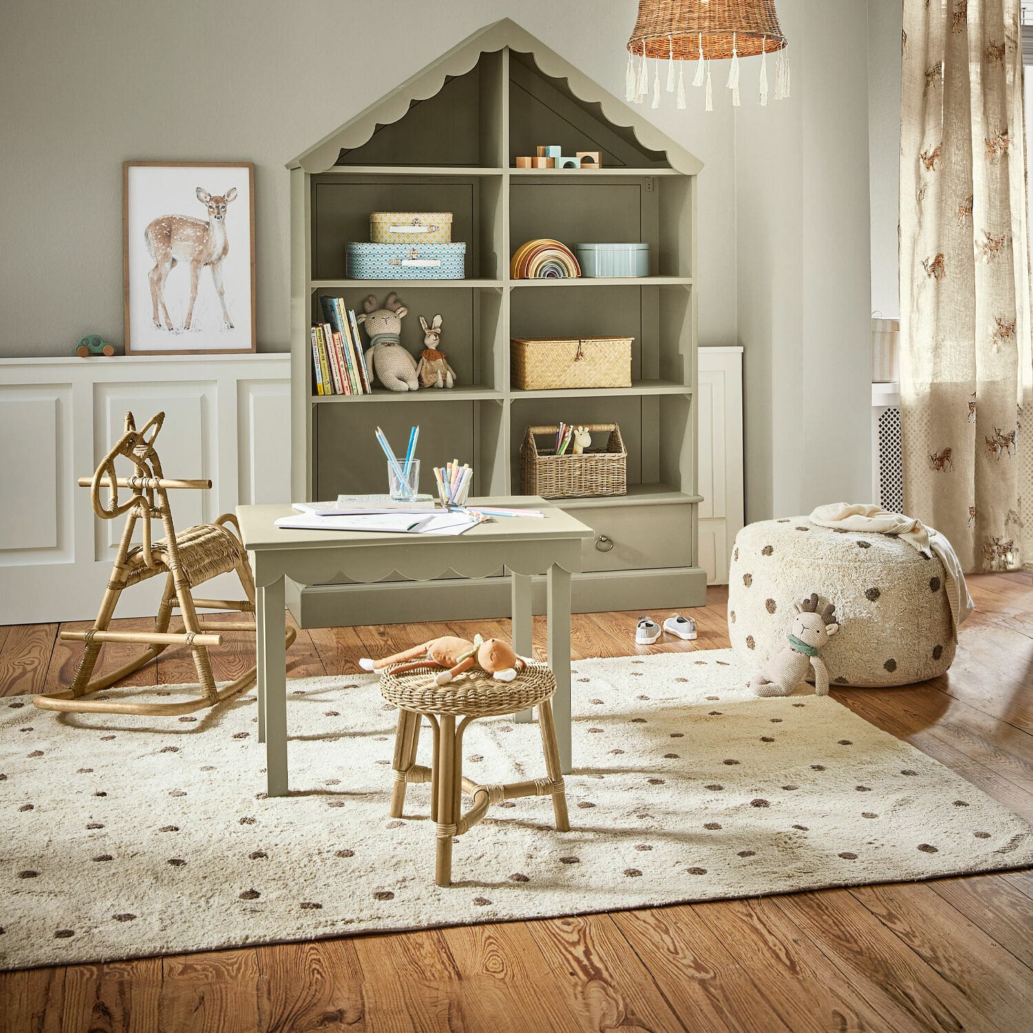 Alfombra Thivalie Acogedora habitación infantil con estantería verde de madera en forma de casa y muebles naturales de ratán