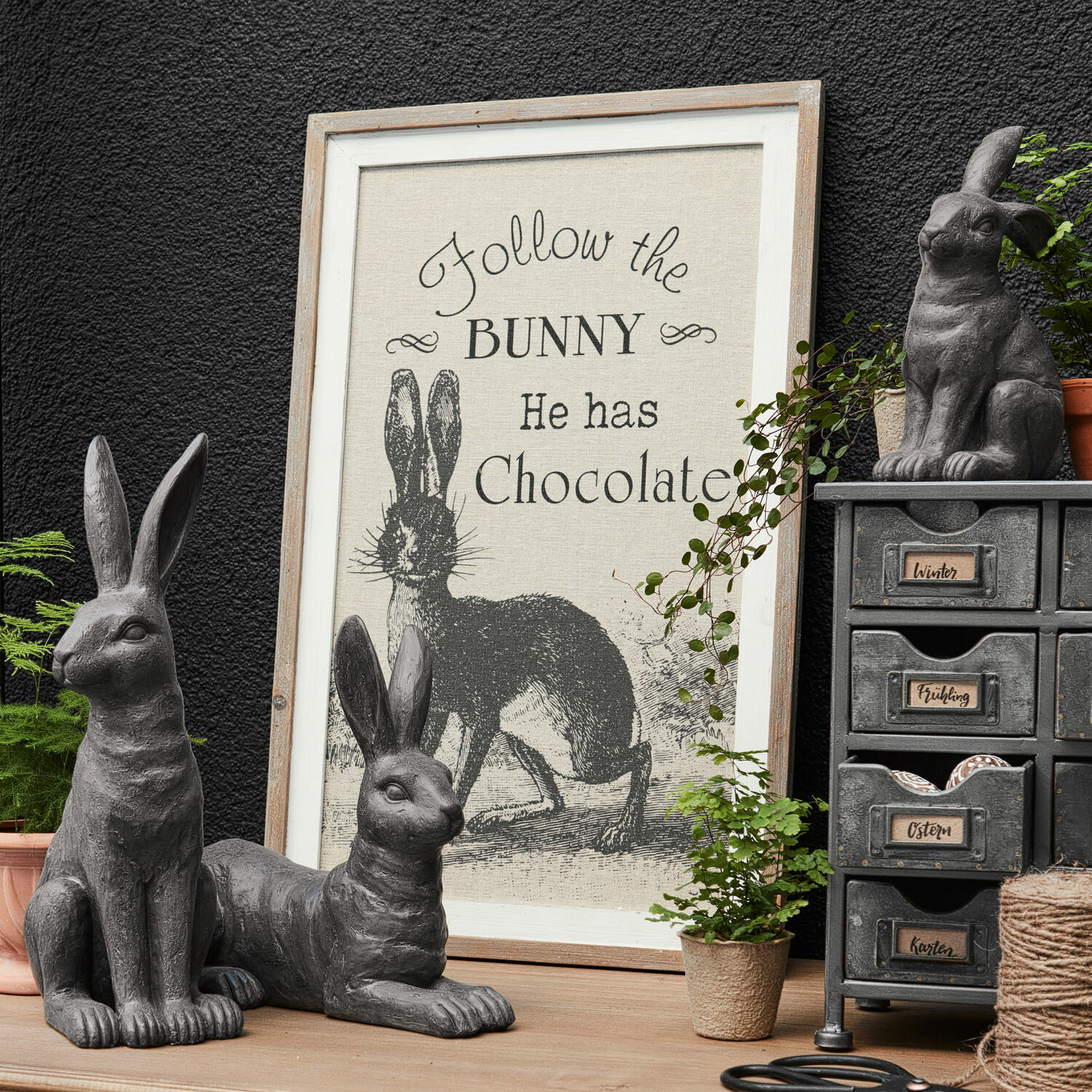 Cuadro decorativo Chocolate Figuras decorativas de conejos grises con marco con texto sobre conejo y chocolate sobre mesa de madera