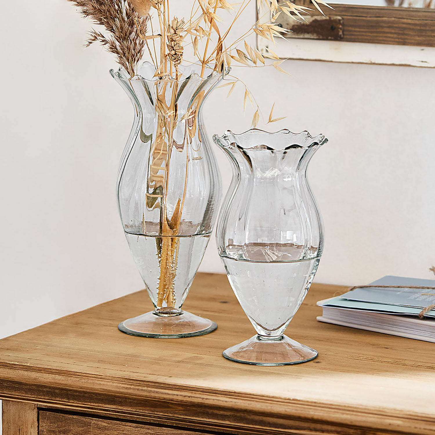 Set de 2 jarrones Deniélou Jarrones de vidrio transparente con borde ondulado sobre mesa de madera, decoración interior elegante