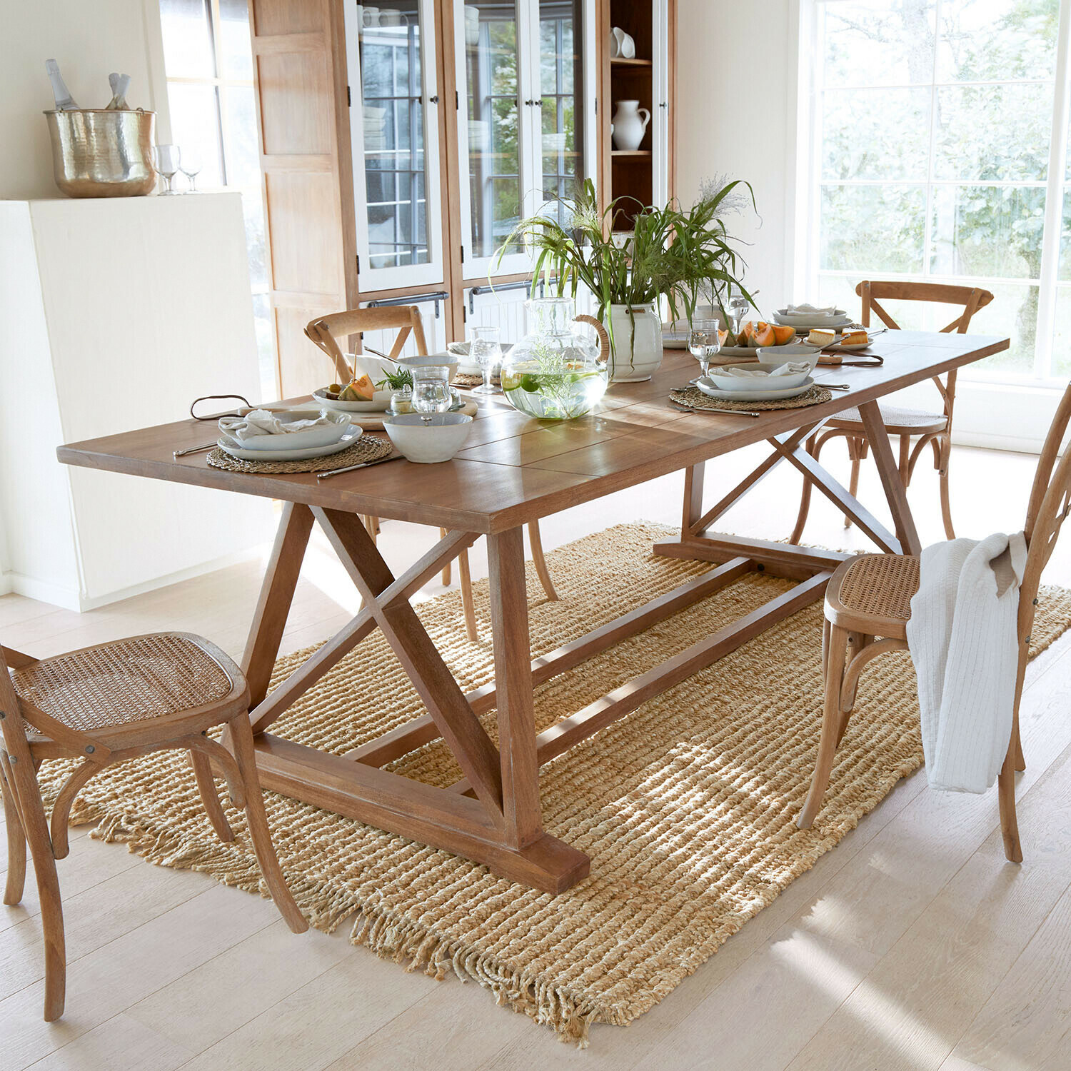 Mesa Isaverny Mesa de comedor de madera con sillas y alfombra natural en habitación luminosa con decoración