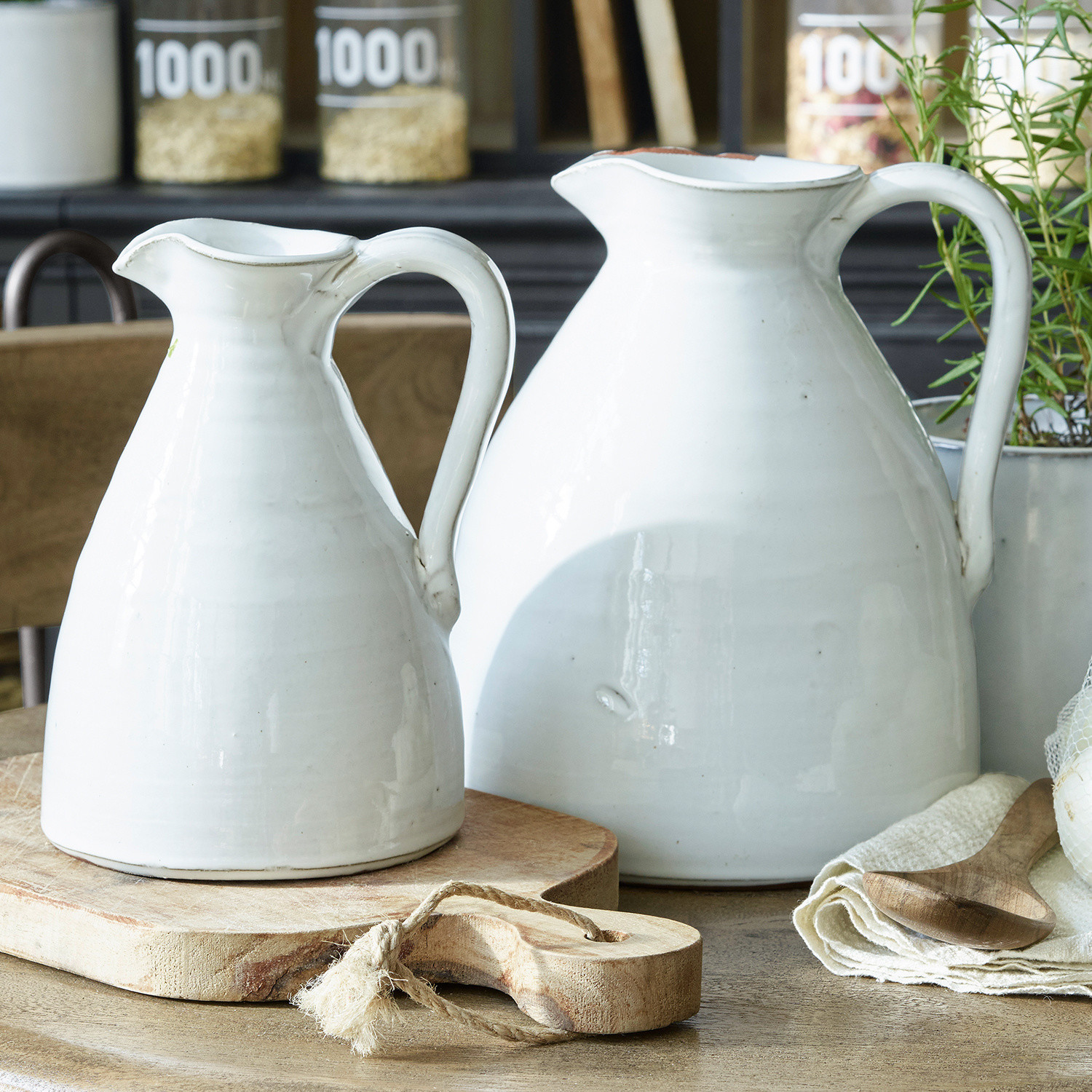 Set de 2 jarrones Yarick Dos jarras de cerámica blanca sobre tabla de madera en cocina de estilo rústico