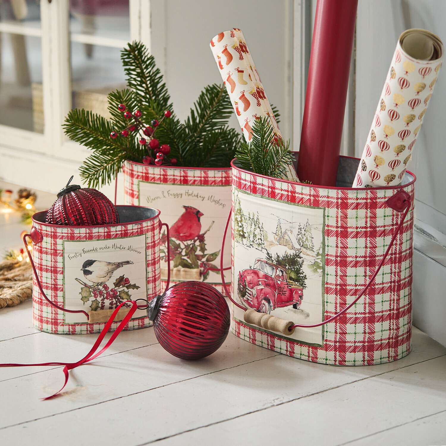 Set de 3 macetas Fuzzy Conjunto de tres cubos metálicos a cuadros rojos y blancos con motivos navideños y ramas verdes decorativas
