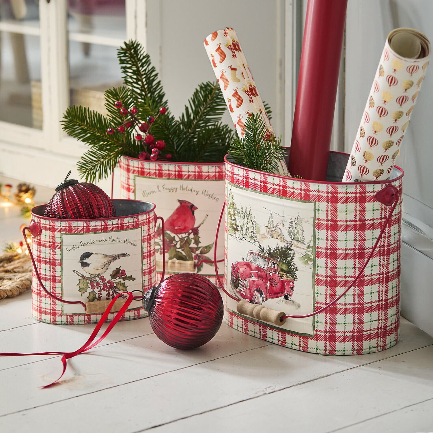 Set de 3 macetas Fuzzy Conjunto de tres cubos metálicos a cuadros rojos y blancos con motivos navideños y ramas verdes decorativas