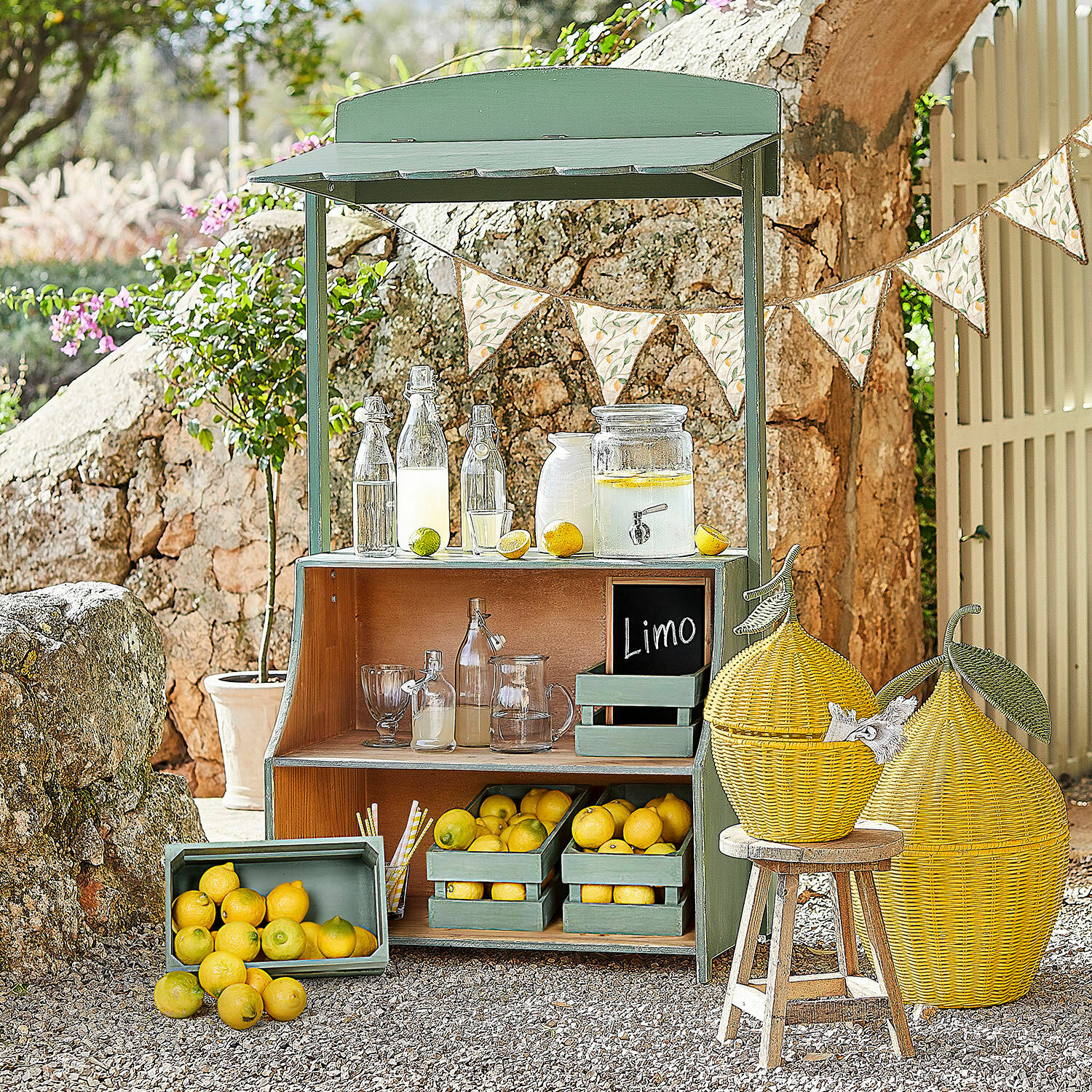 Puesto de limonada Éclairon Estante de madera verde con limones y botellas de vidrio para limonada en jardín