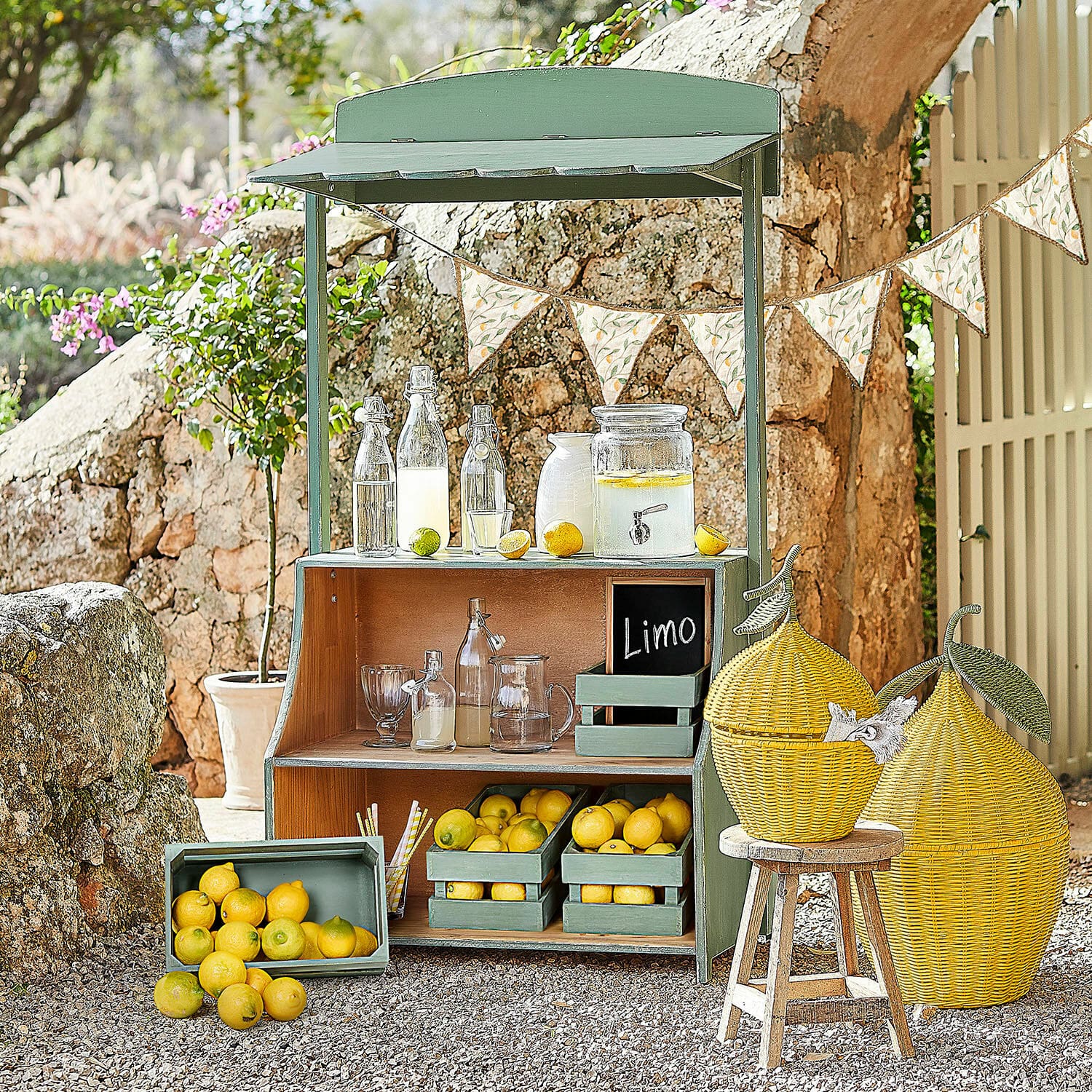 Puesto de limonada Éclairon Estante de madera verde con limones y botellas de vidrio para limonada en jardín