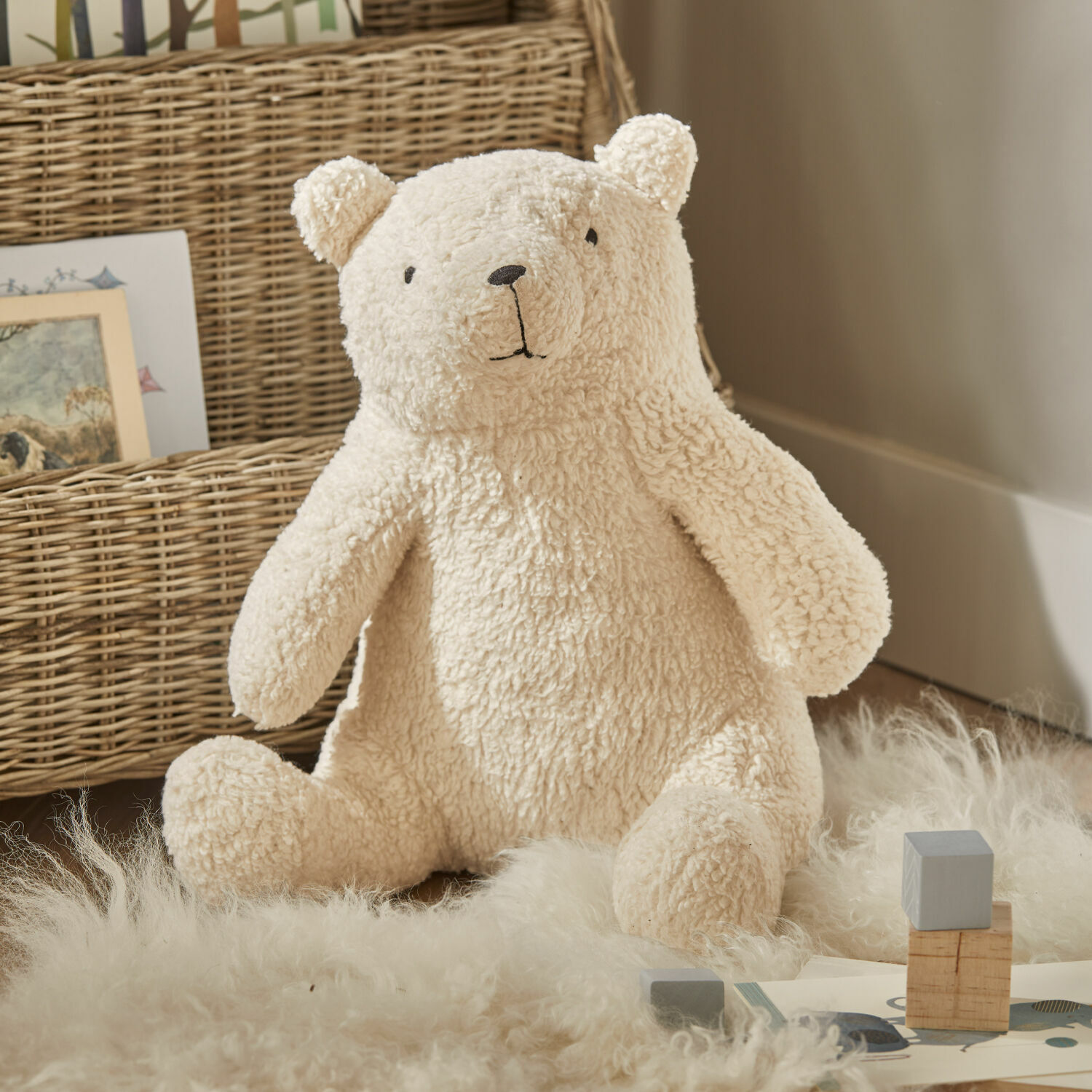 Peluche Hugo Oso de peluche suave color crema sobre alfombra de materiales naturales, decoración infantil