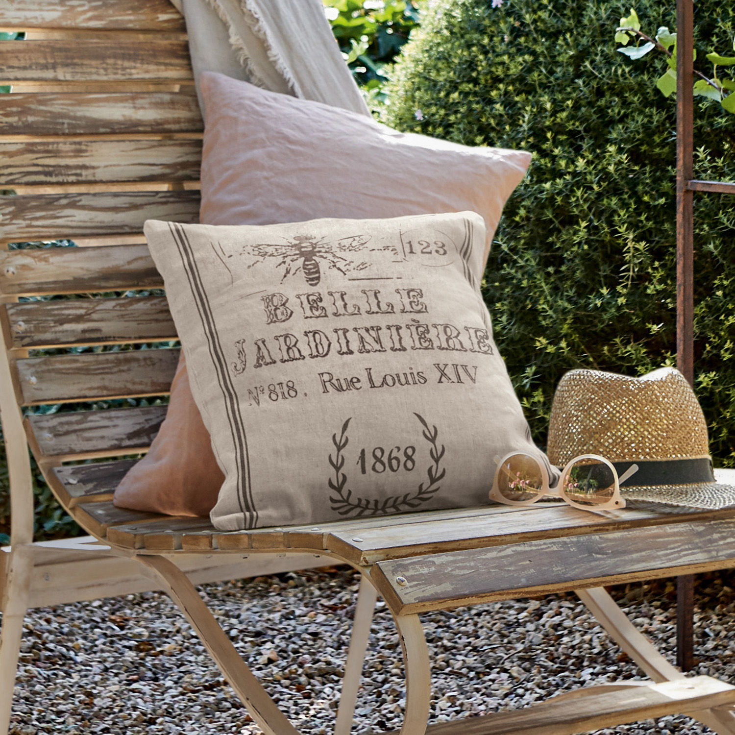 Funda de cojín Abelle Cojín decorativo de lino beige con estampado vintage sobre banco de madera en jardín exterior