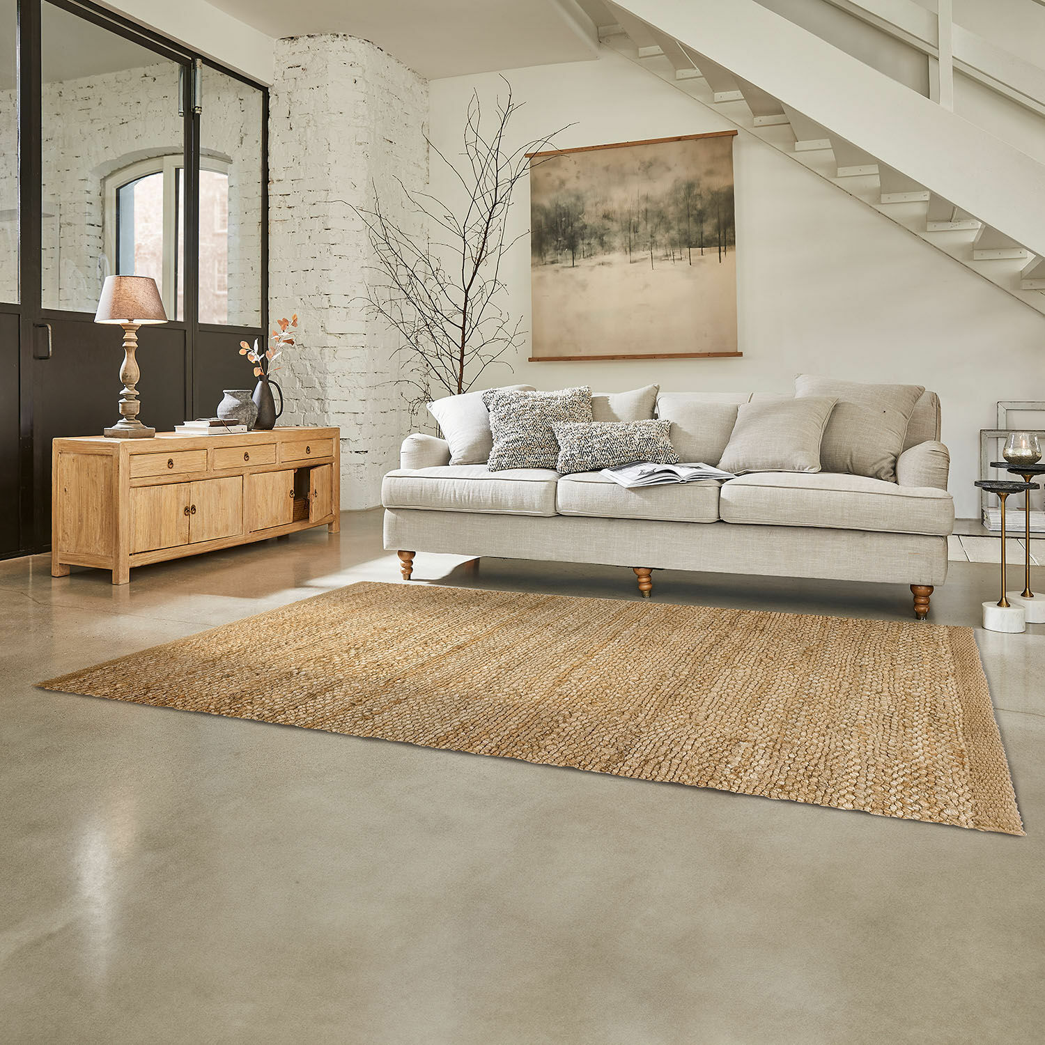 Alfombra Abitain Alfombra natural de yute beige en sala con sofá gris claro y mueble de madera