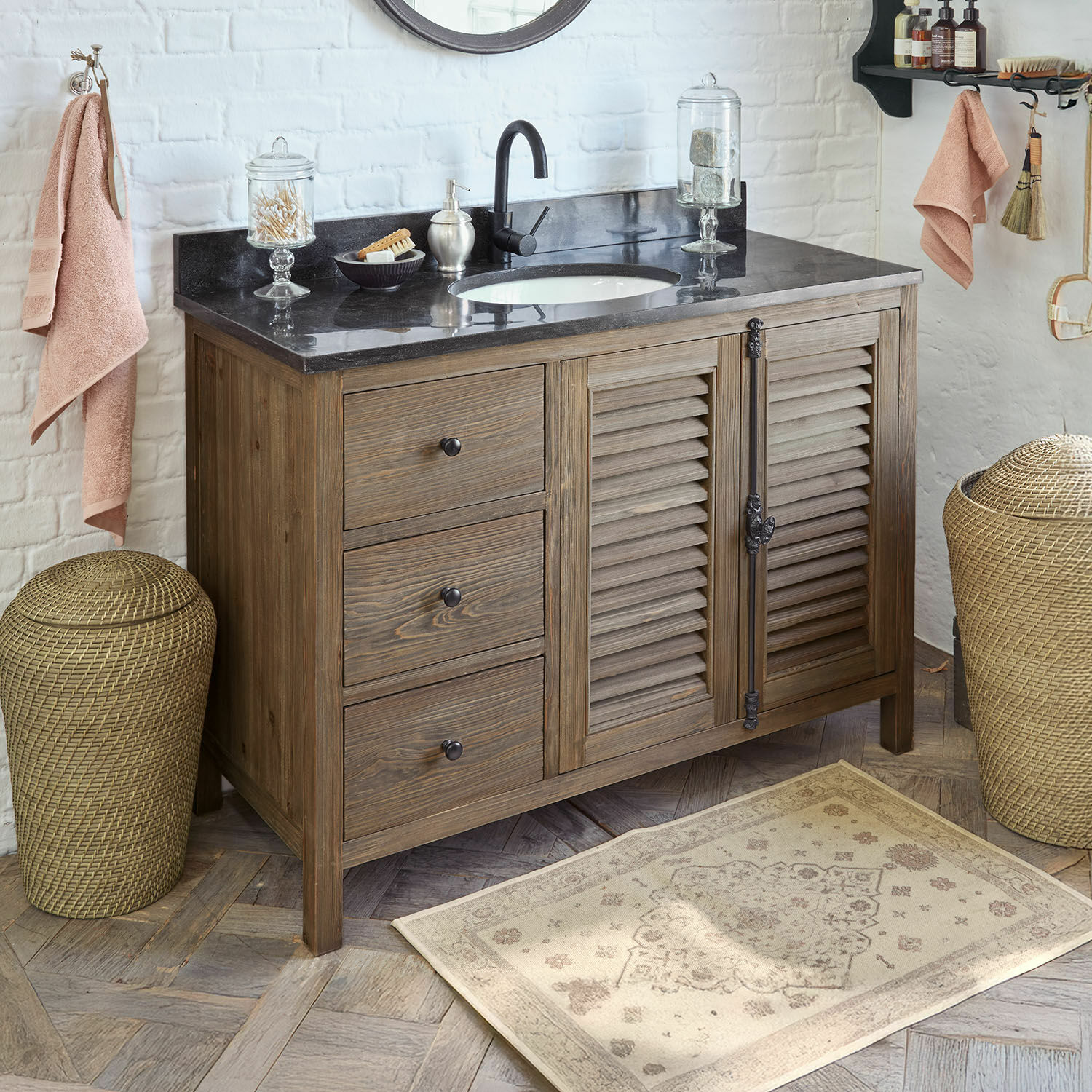 Mueble de baño de madera con encimera de mármol negro y lavabo, estilo rústico