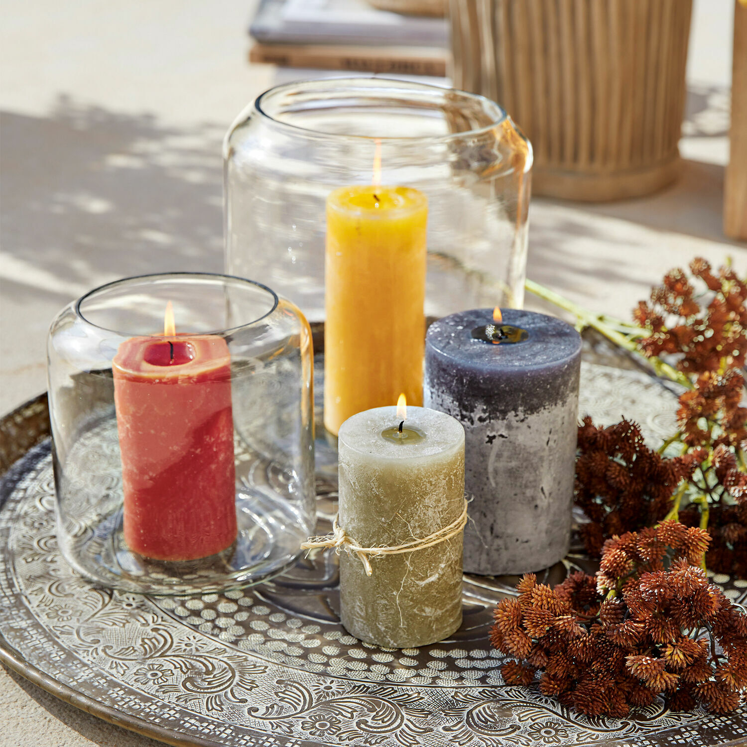 Conjunto de cuatro velas de colores sobre bandeja metálica decorativa para decoración interior