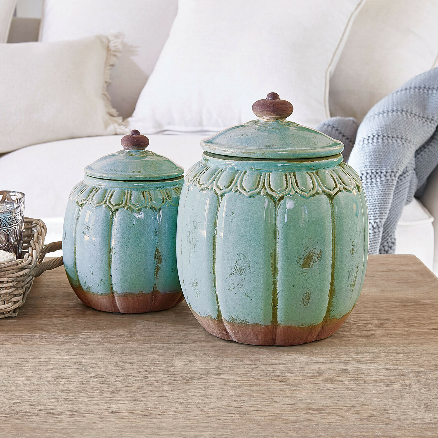 Set de 2 tarros Valerosas Conjunto de dos tarros de cerámica verde con detalles marrones sobre mesa de madera