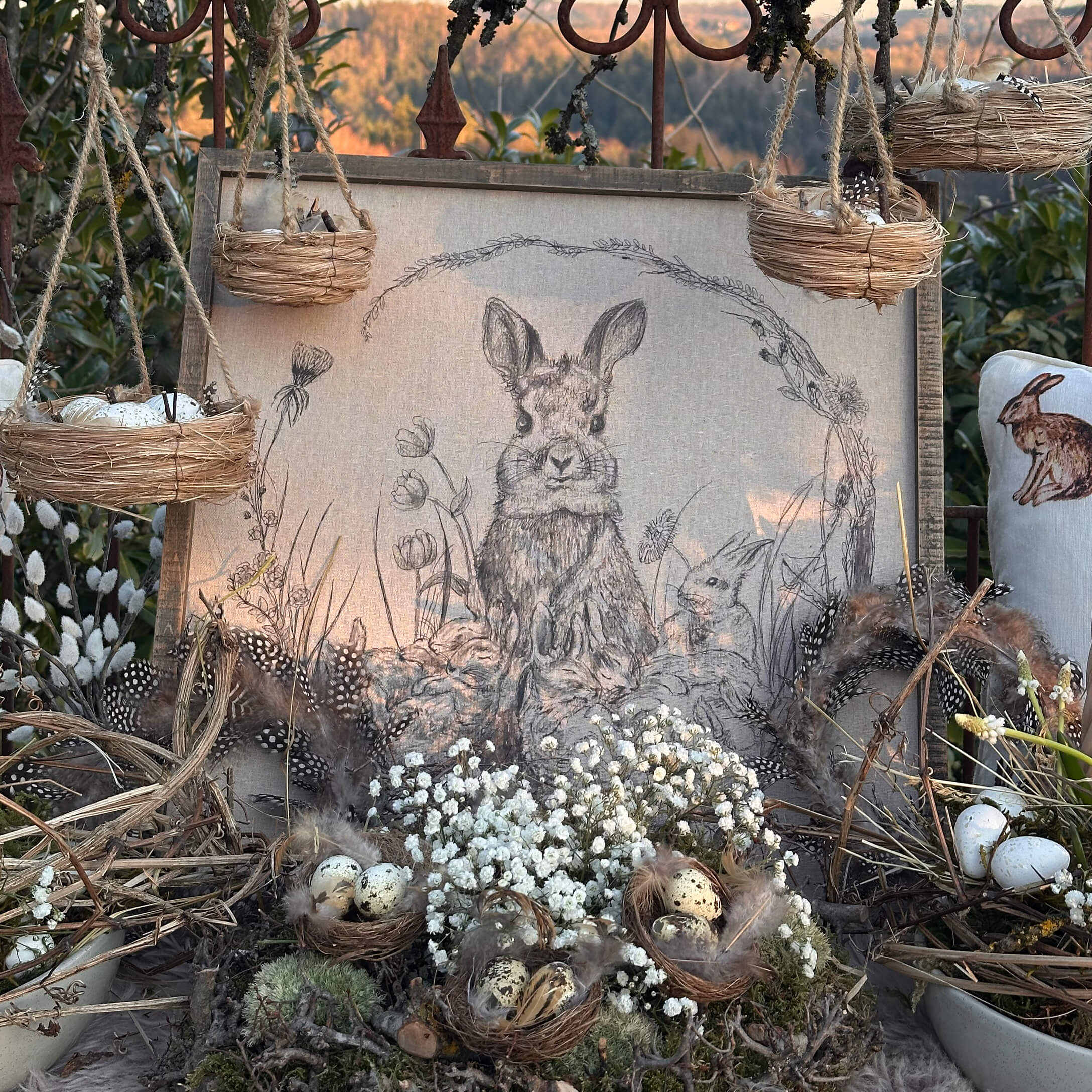 Decoración natural de Pascua con nidos, plumas y dibujo de conejo en tela de lino