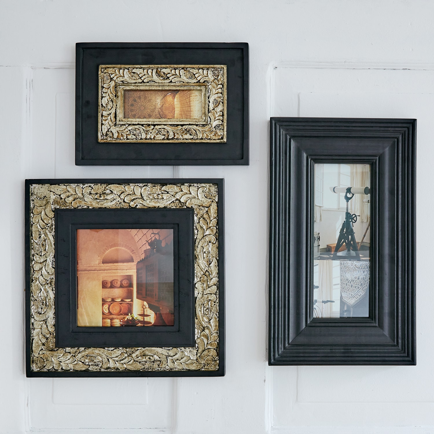 Conjunto de tres marcos negros con detalles dorados y fotos vintage colgados en pared blanca