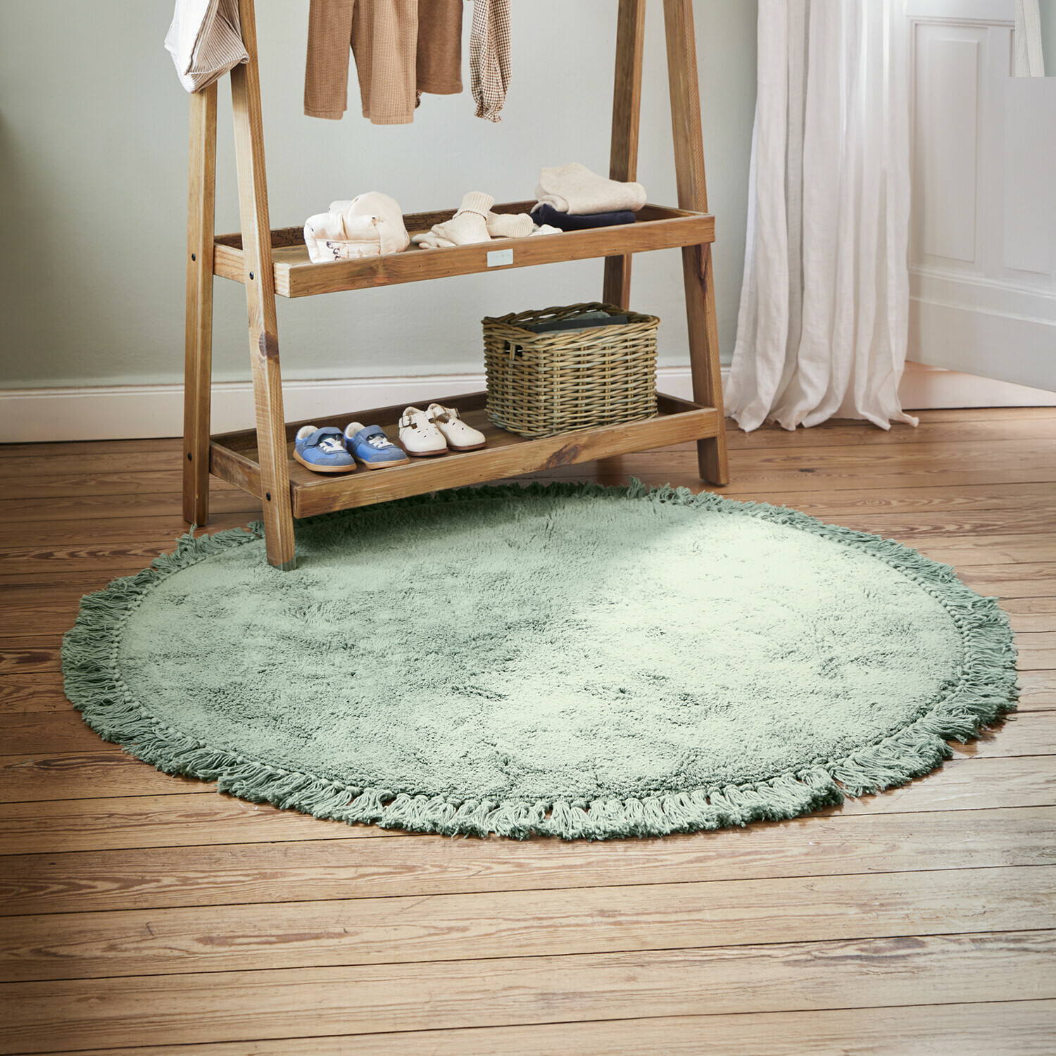 Alfombra Ivalex Alfombra redonda verde suave con flecos sobre suelo de madera en habitación infantil