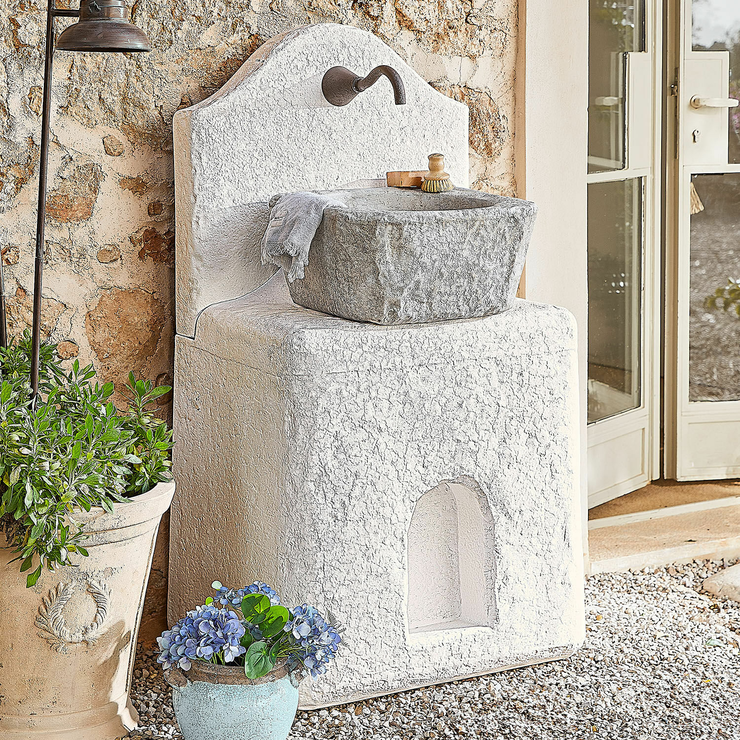 Fuente Pisticci Lavabo de jardín de piedra blanca con cuenca gris y grifo metálico, decoración exterior con plantas