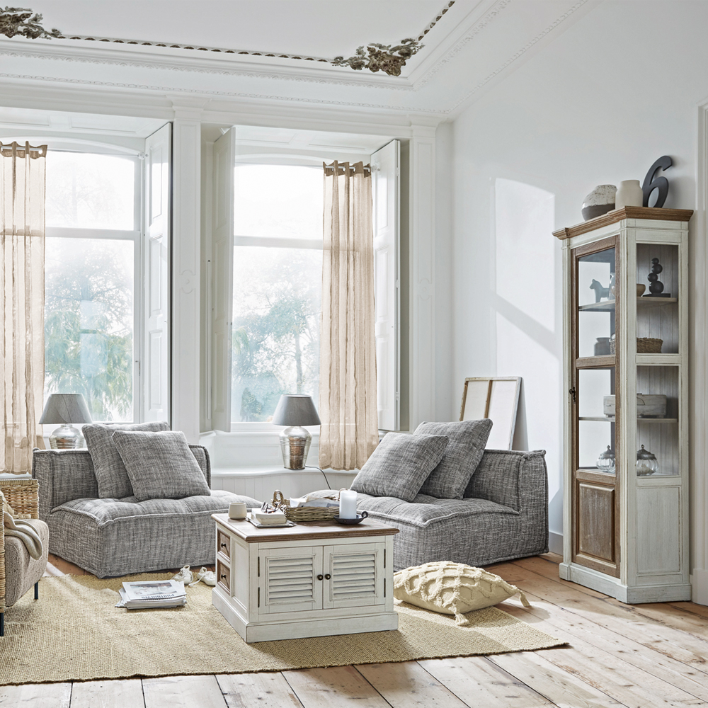 Salón acogedor con sillones grises y mueble blanco de madera sobre alfombra de yute, estilo escandinavo