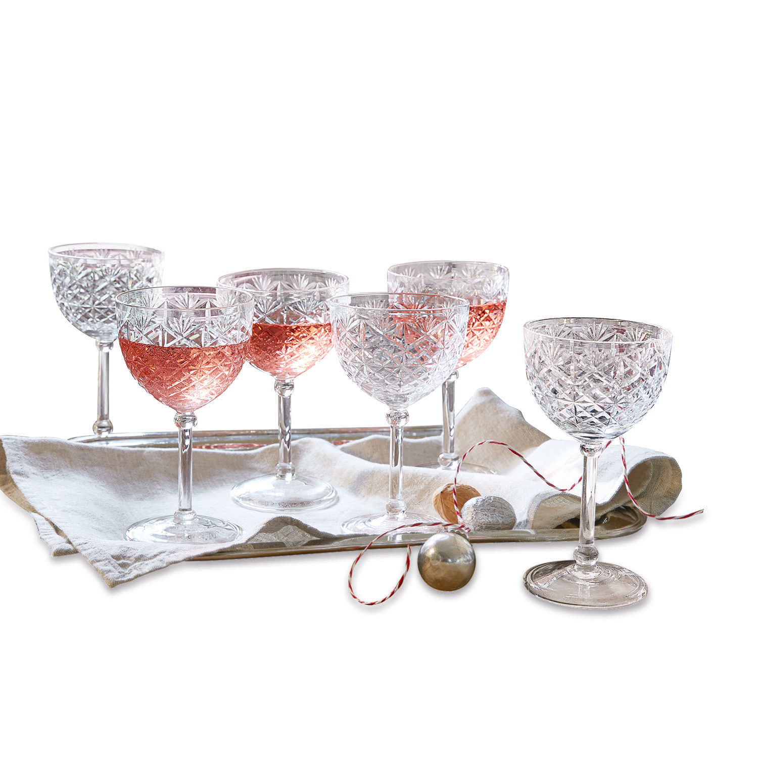 Set de 6 copas Olite Conjunto de seis copas de cristal para vino con bebida rosada sobre bandeja con servilleta de lino