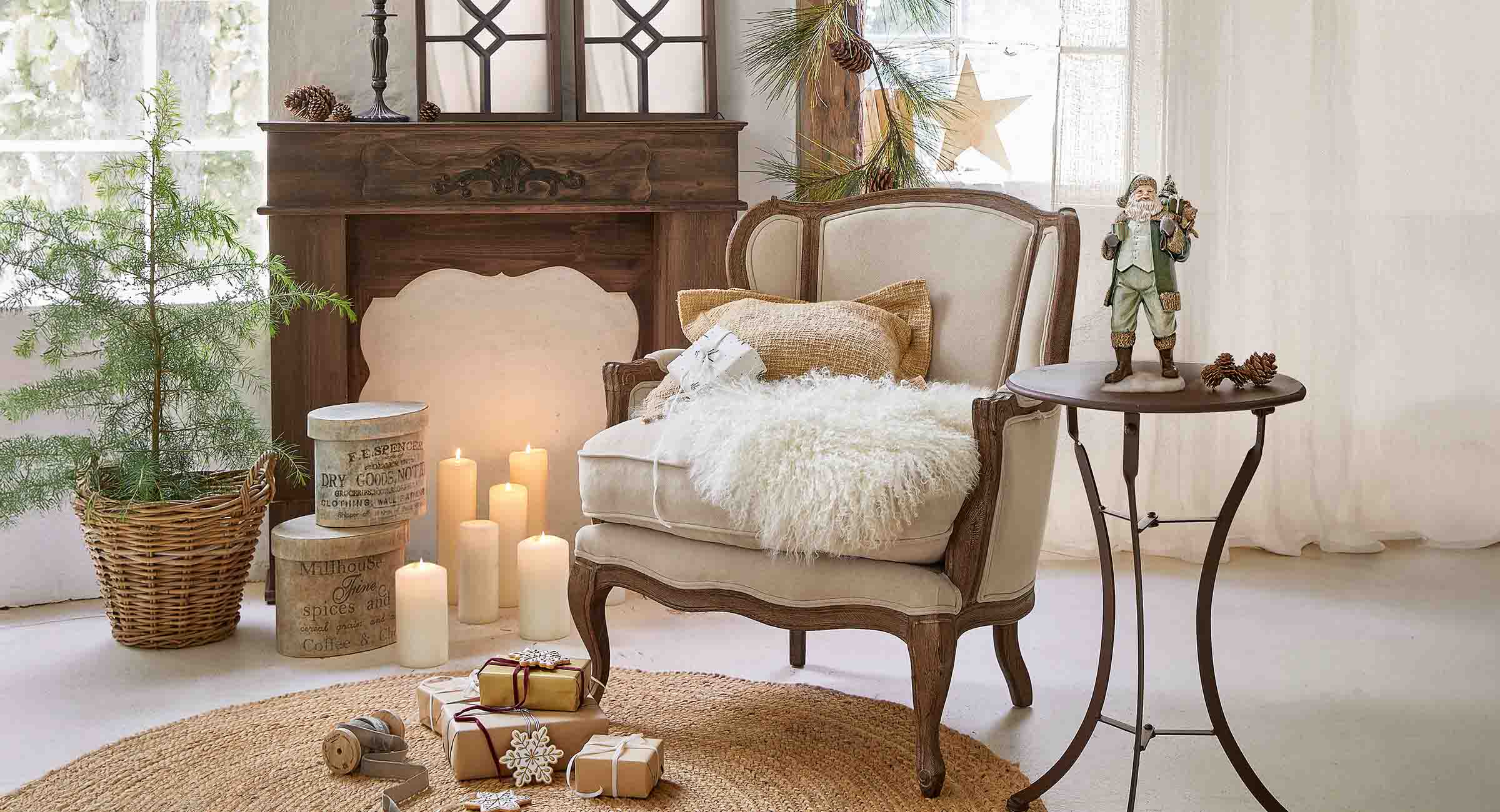 Sillón beige con marco de madera, cojín y manta de piel, en ambiente decorado para Navidad