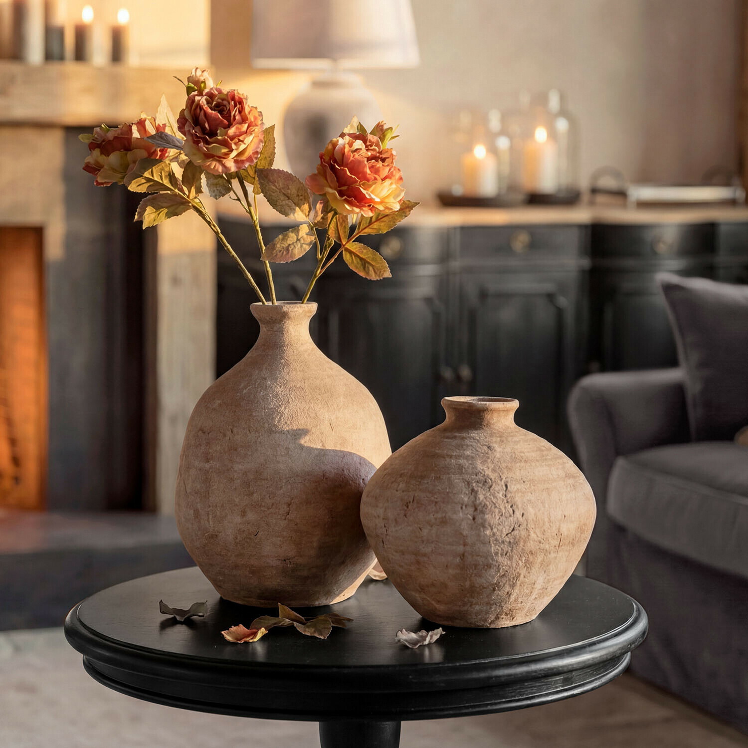 Set de 2 jarrones decorativos Kelvador Dos jarrones rústicos de cerámica beige sobre mesa negra con flores decorativas