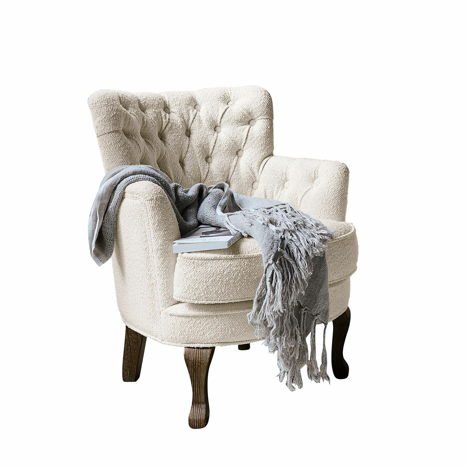 Sillón Calgary Sillón beige de tela bouclé con patas de madera oscura, manta gris y libro encima