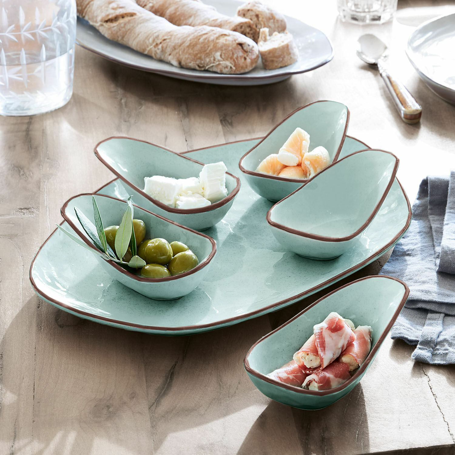Set de 5 cuencos y plato de servir Biarré Juego de cuencos de cerámica verde menta con borde marrón para aperitivos sobre mesa de madera