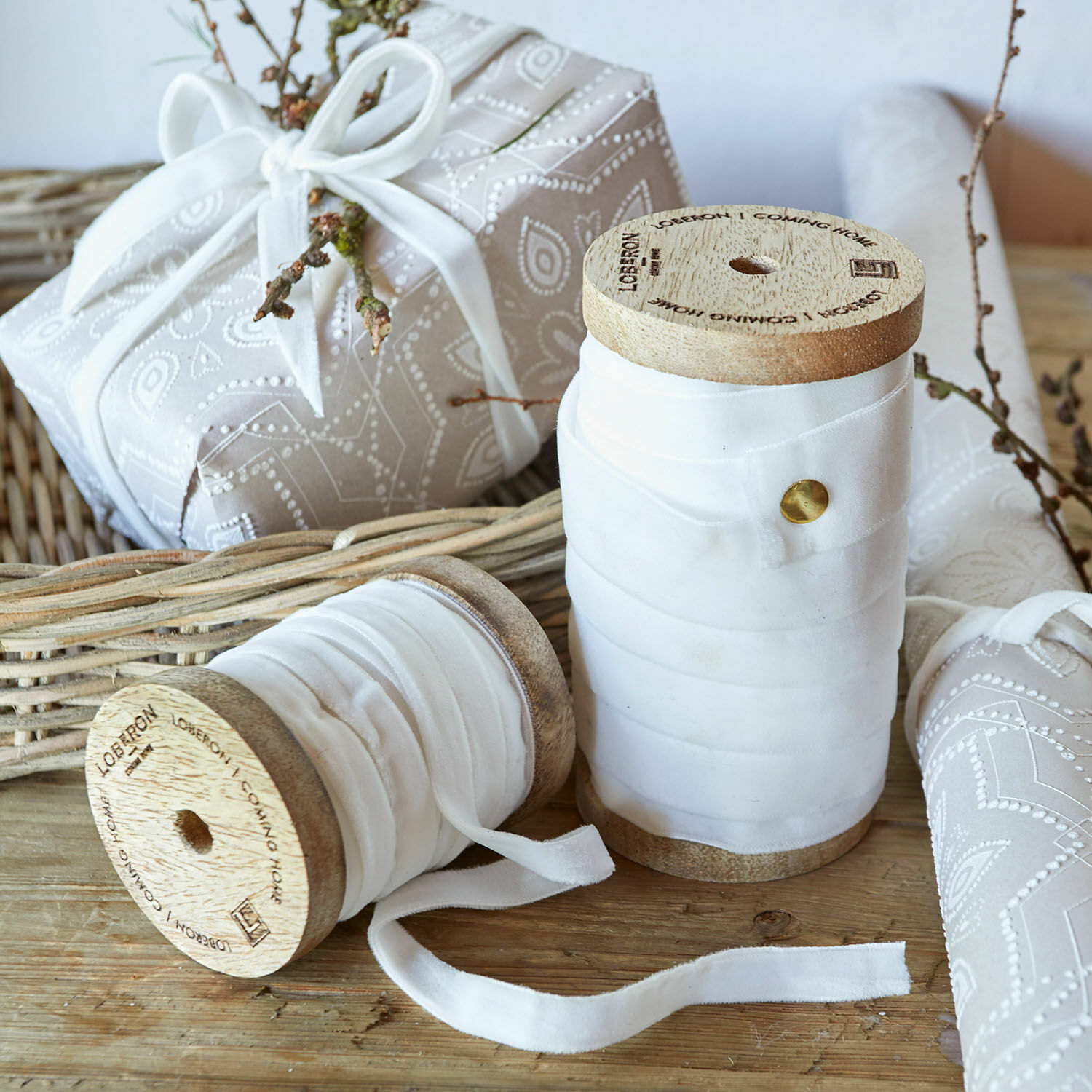 Carretes de madera con cinta de algodón blanca sobre mesa de madera rústica para decoración