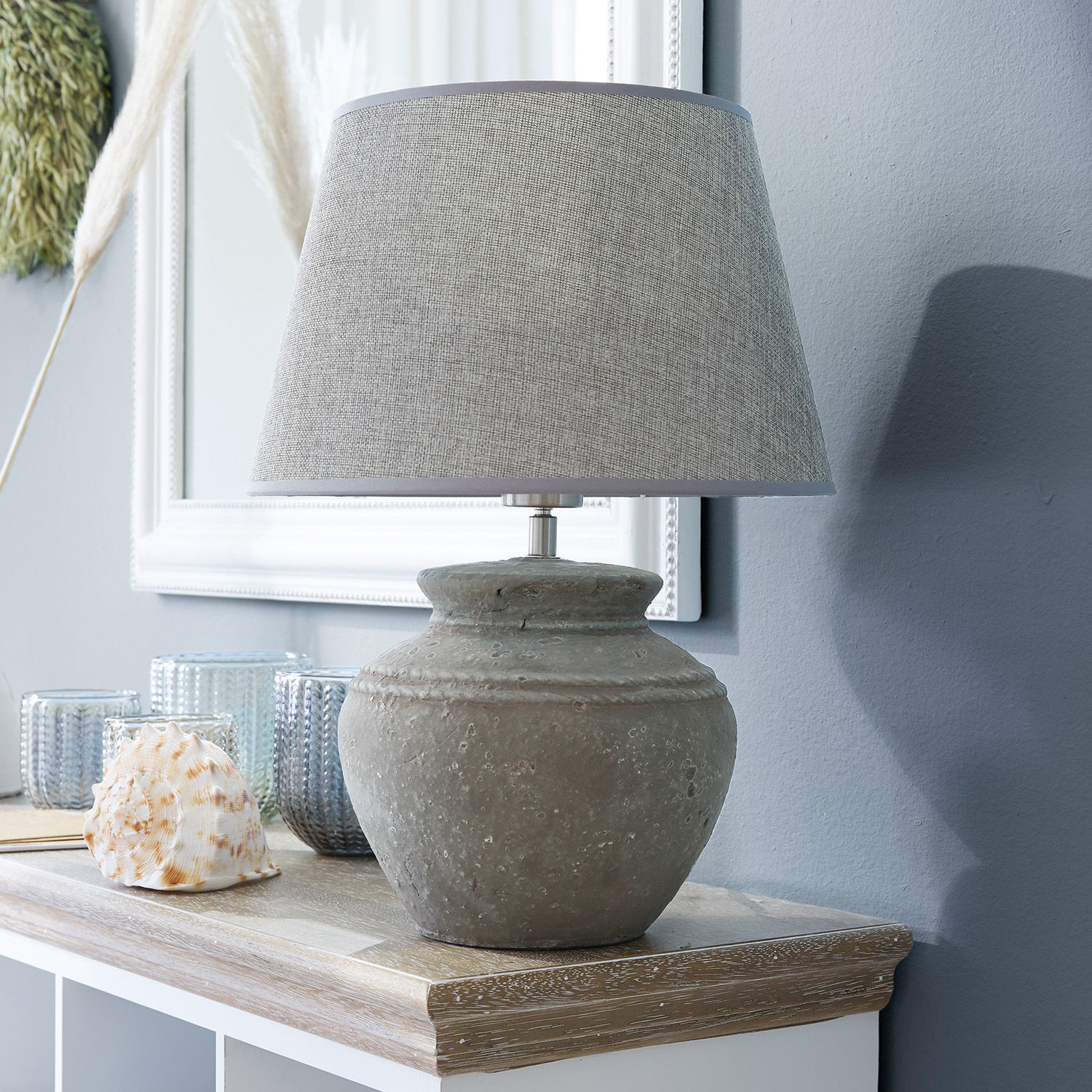 Lámpara de mesa Cleveland Lámpara de mesa con base de cerámica gris y pantalla beige sobre superficie de madera