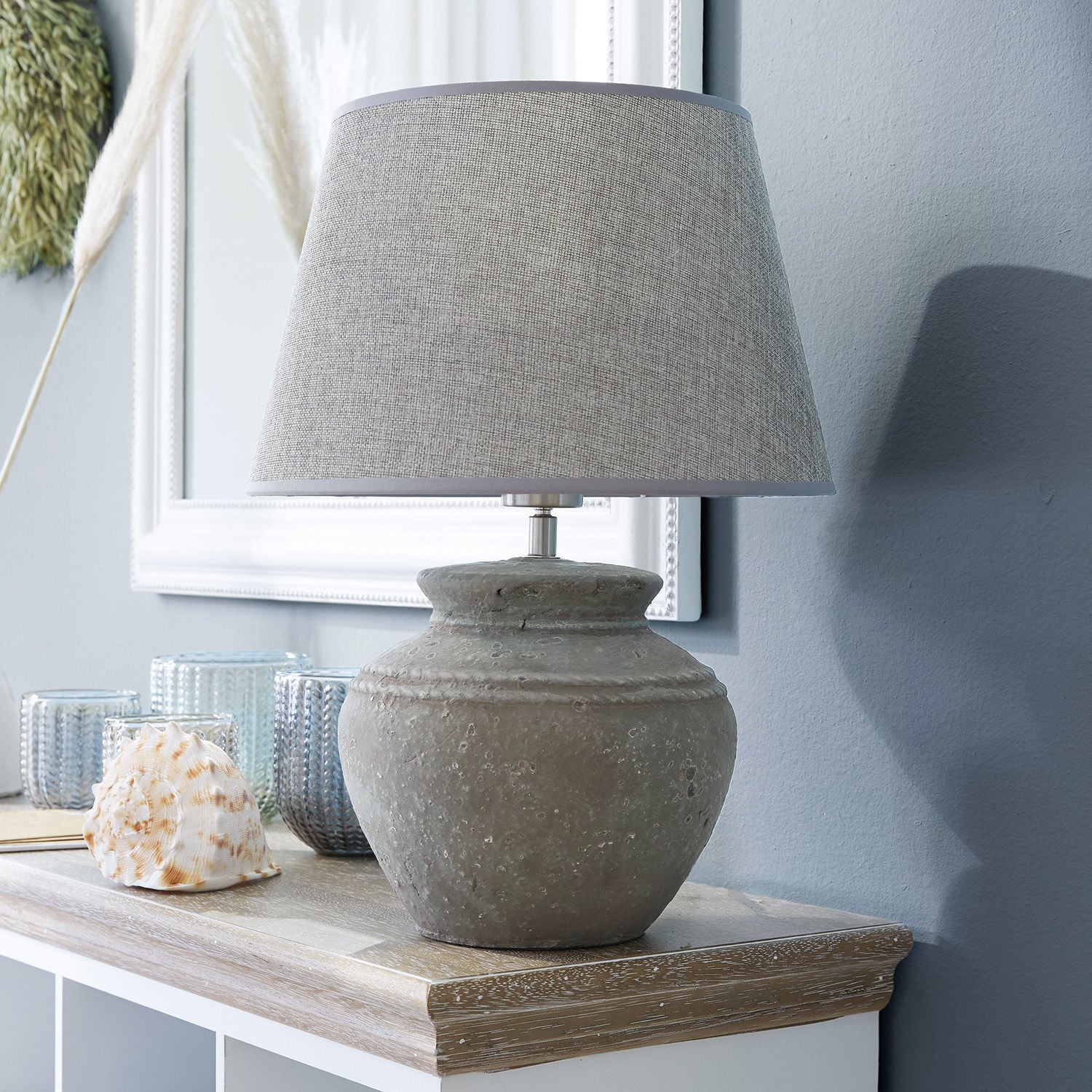 Lámpara de mesa Cleveland Lámpara de mesa con base de cerámica gris y pantalla beige sobre superficie de madera