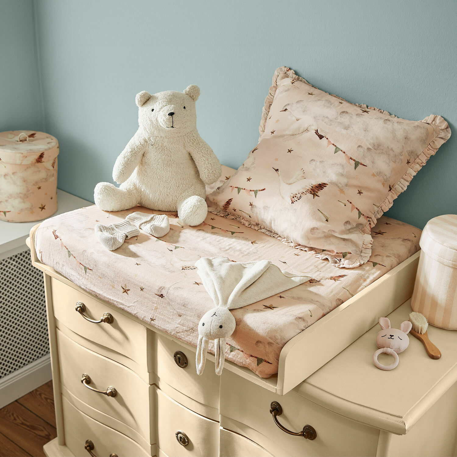 Cambiador Aiguillon Cambiador beige sobre cómoda con funda rosa y peluches en habitación infantil