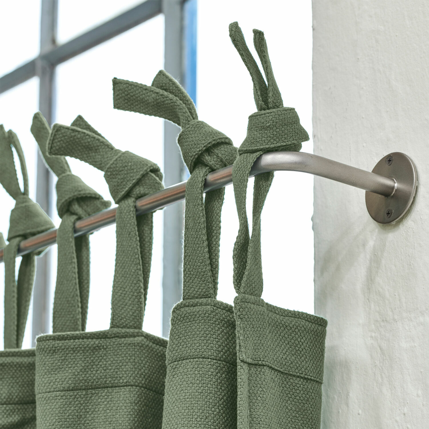Barra de cortina Omara Cortinas verdes de algodón colgadas en barra metálica en interior moderno