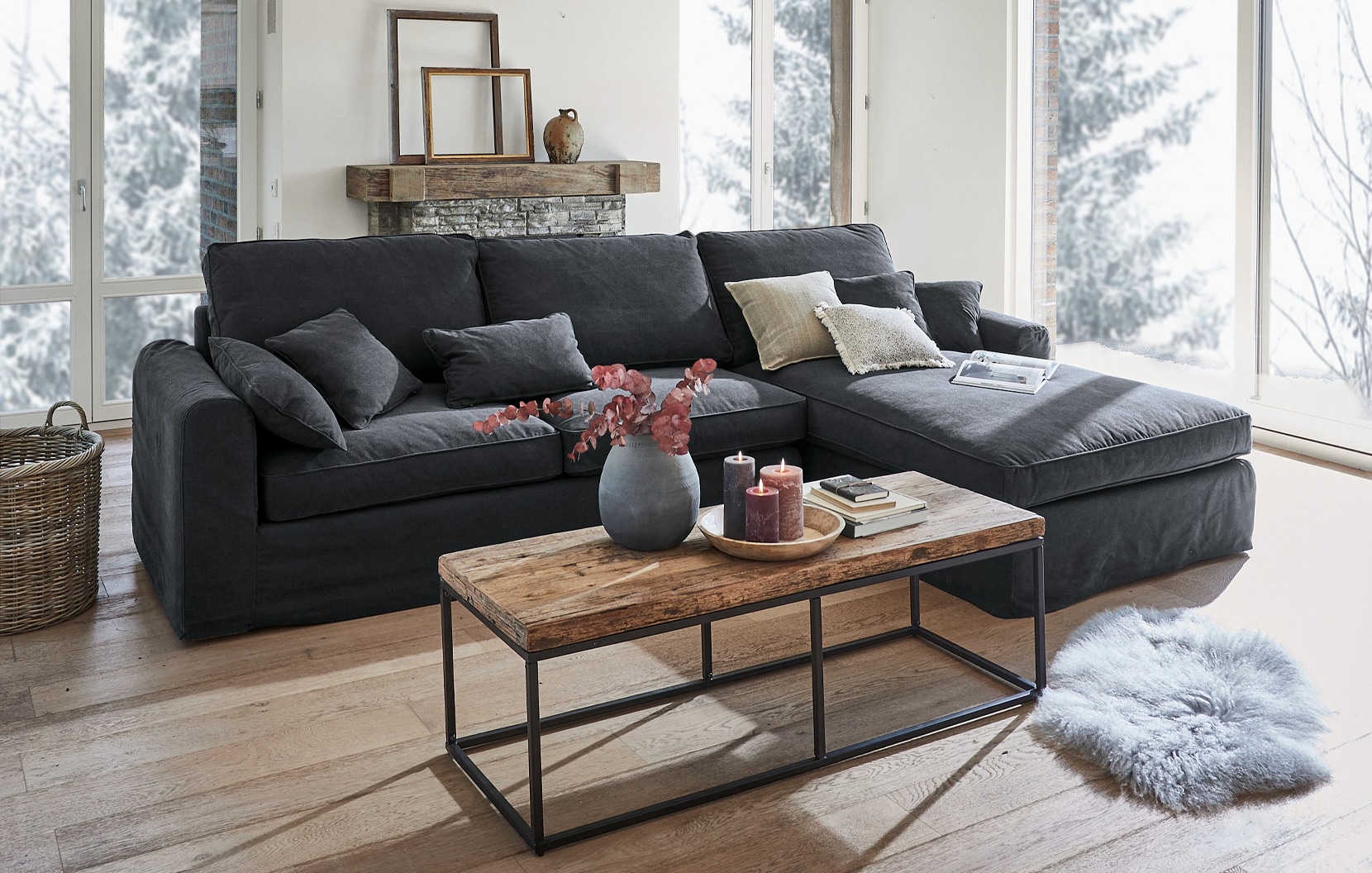 Sofá rinconero gris de tela estilo industrial con mesa de madera y decoración en salón luminoso