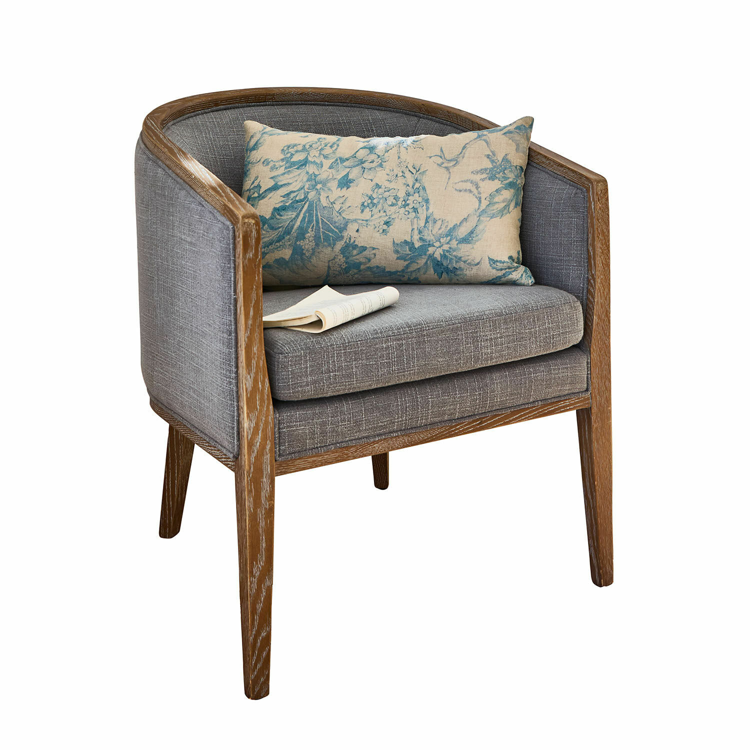 Sillón con estructura de madera y tapizado gris con cojín decorativo azul floral
