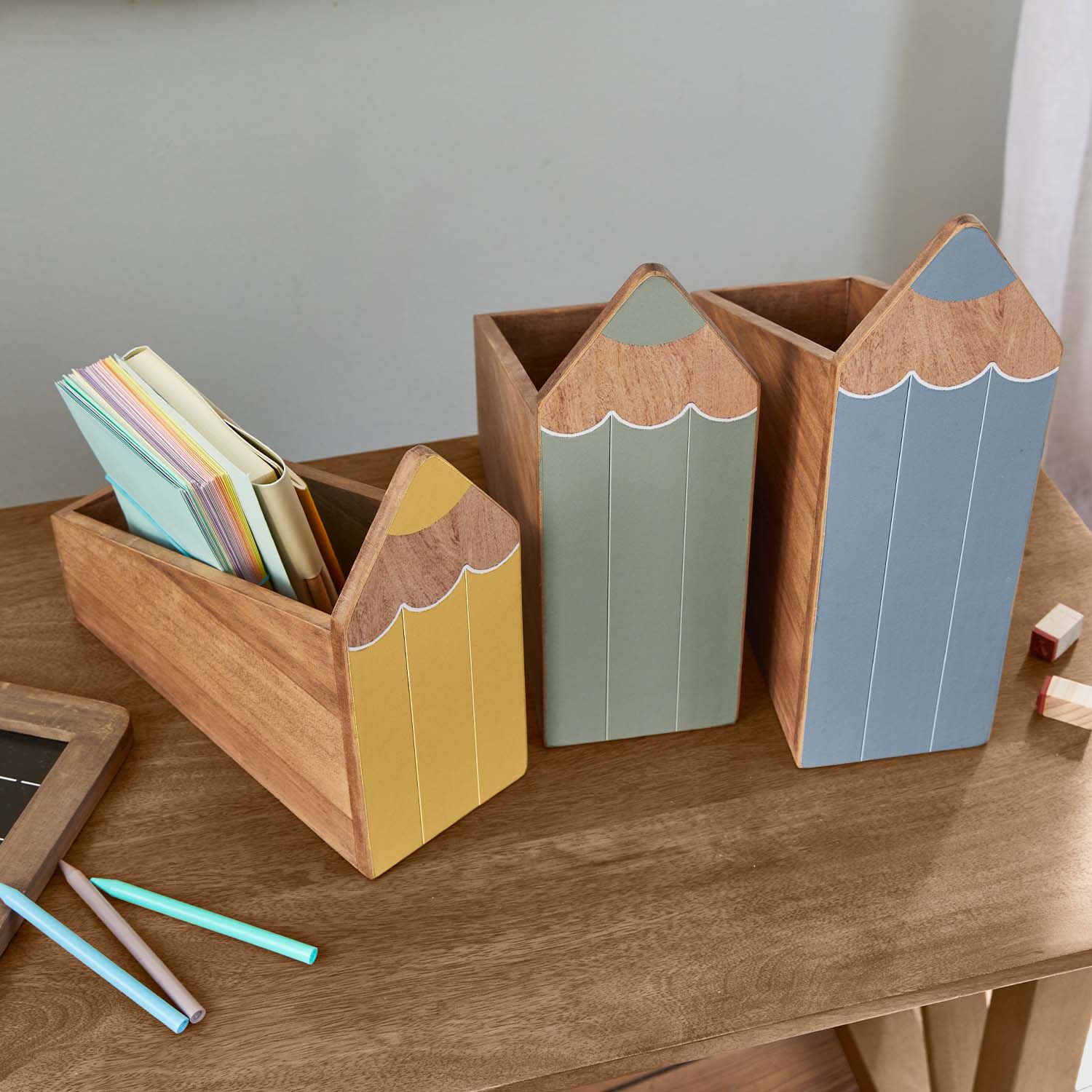 Organizadores de escritorio de madera con forma de lápices en amarillo, verde y azul para ordenar
