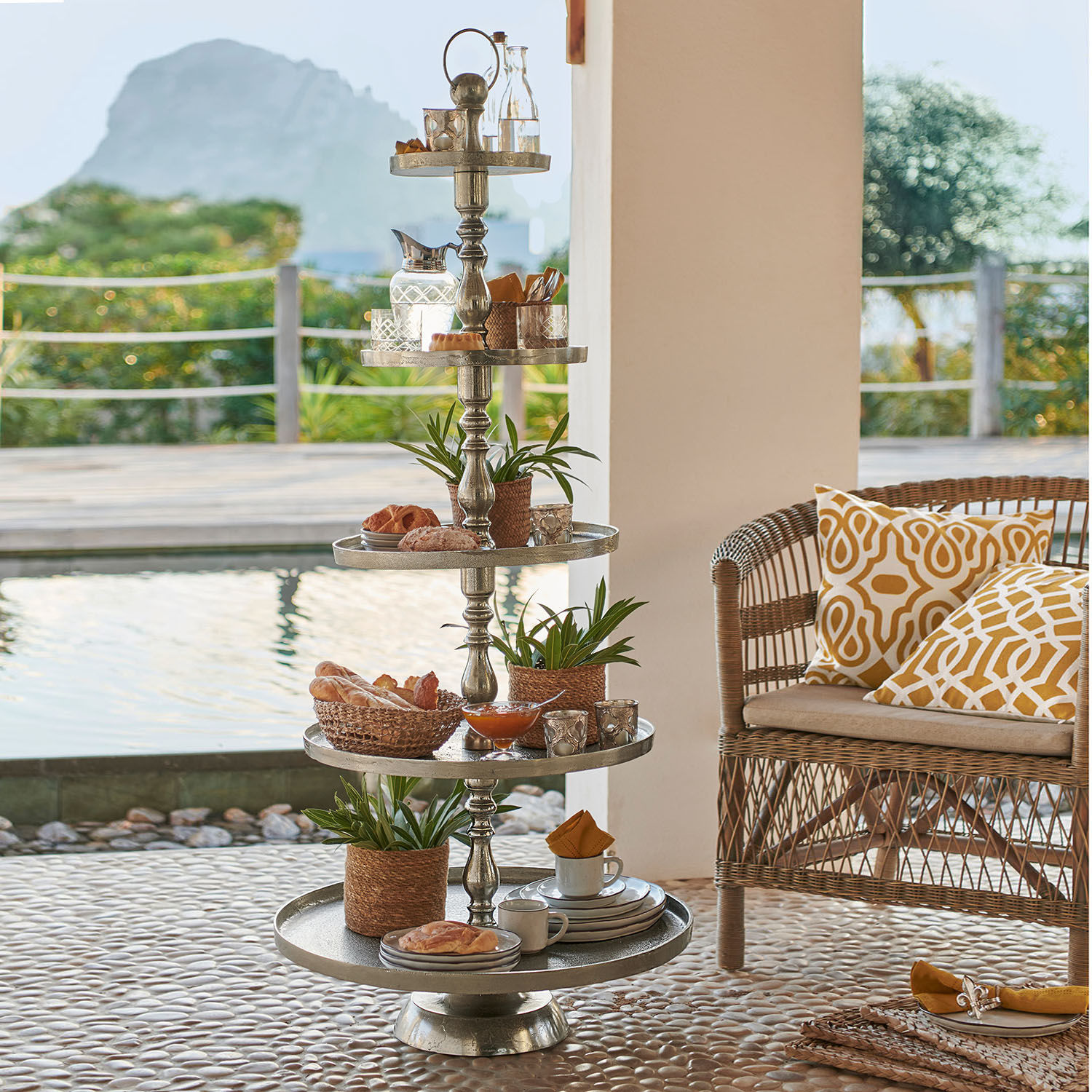 Estantería Magonie Soporte metálico de cinco niveles con decoraciones y aperitivos en terraza junto a piscina
