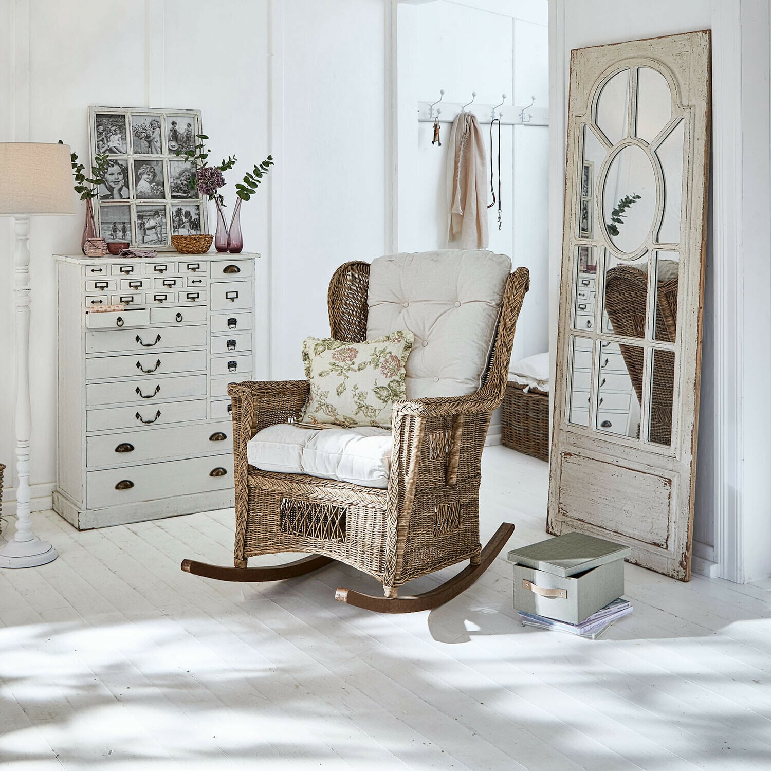Mecedora Jeveren Mecedora de ratán con cojines crema en interior luminoso con suelo blanco