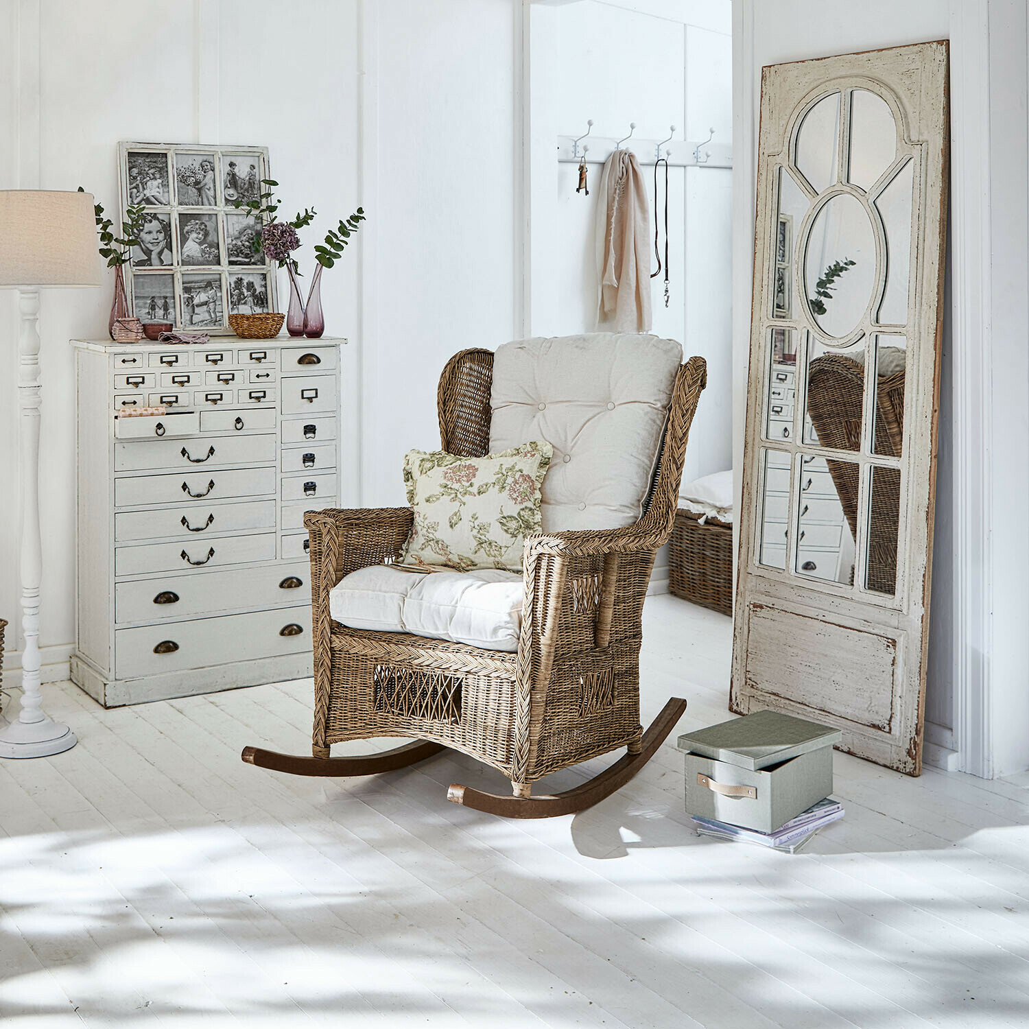 Mecedora Jeveren Mecedora de ratán con cojines crema en interior luminoso con suelo blanco