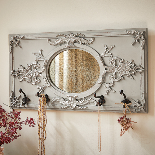 Perchero de pared decorativo gris con espejo ovalado y tres ganchos metálicos para joyas