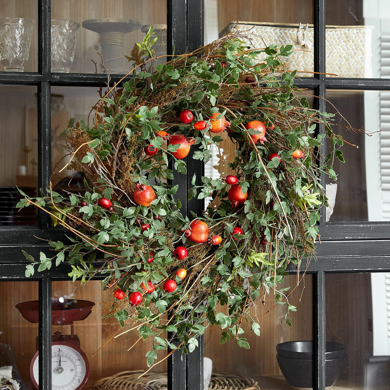 Corona Karidah Corona decorativa con hojas verdes y frutos rojos en puerta negra, adorno natural para interiores