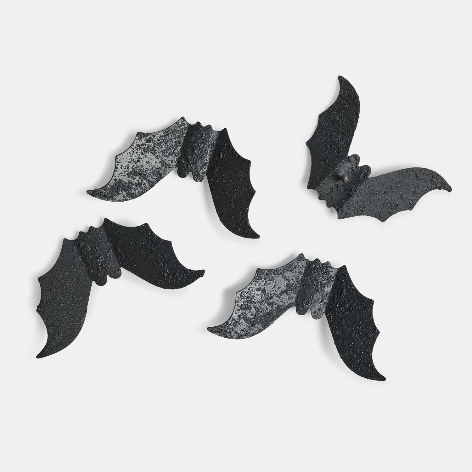 Set de 4 pines decorativos Brynnach Cuatro decoraciones de metal negro en forma de murciélagos con textura rugosa sobre fondo blanco