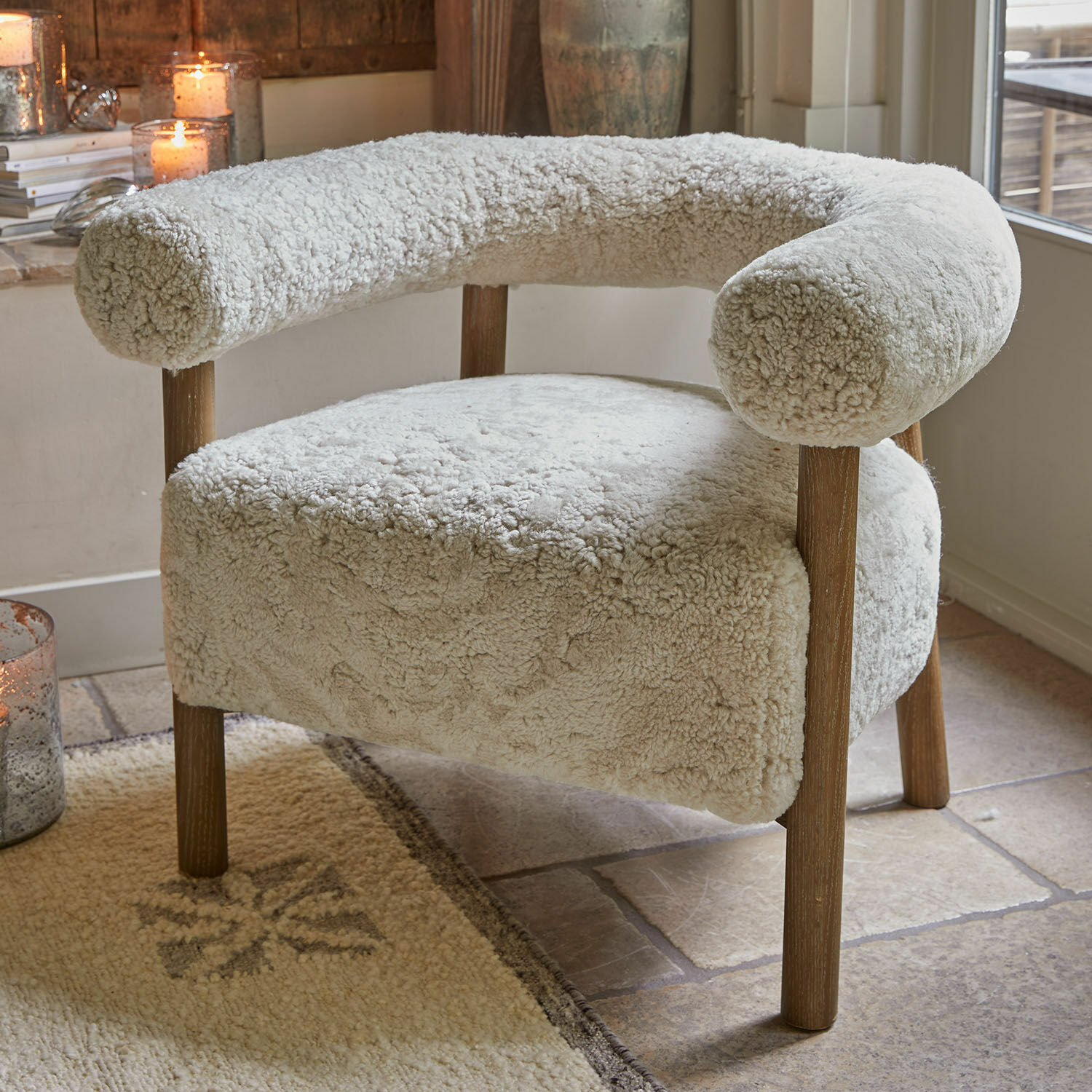 Sillón beige claro con tapizado suave y patas de madera para sala de estar