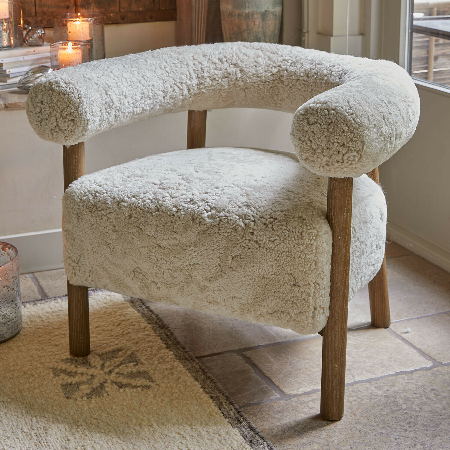 Sillón beige claro con tapizado suave y patas de madera para sala de estar