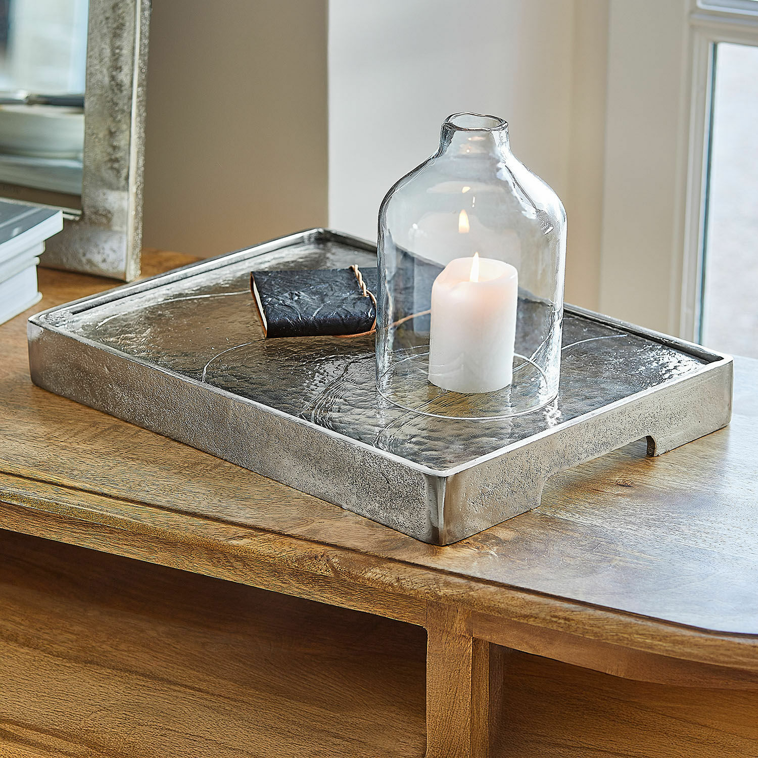Bandeja Yvelissel Bandeja decorativa de metal plateado con campana de vidrio transparente y vela blanca sobre mesa de madera