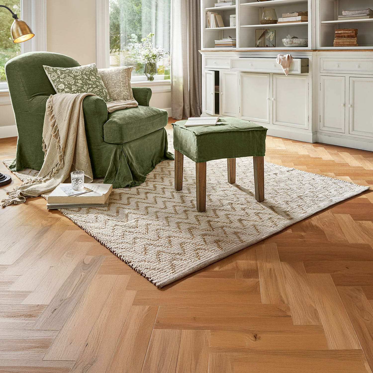Alfombra reversible Vendeline Sillón verde de tela con reposapiés a juego en sala acogedora con alfombra y suelo de madera